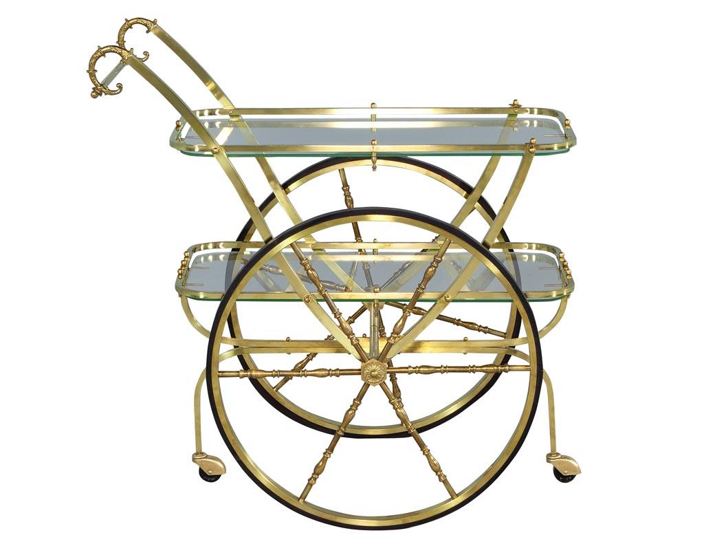 Vintage midcentury Italian brass bar cart. Double wheels with two glass shelves. Imported from Italy, made in the 1970s in a Mid-Century Modern design.