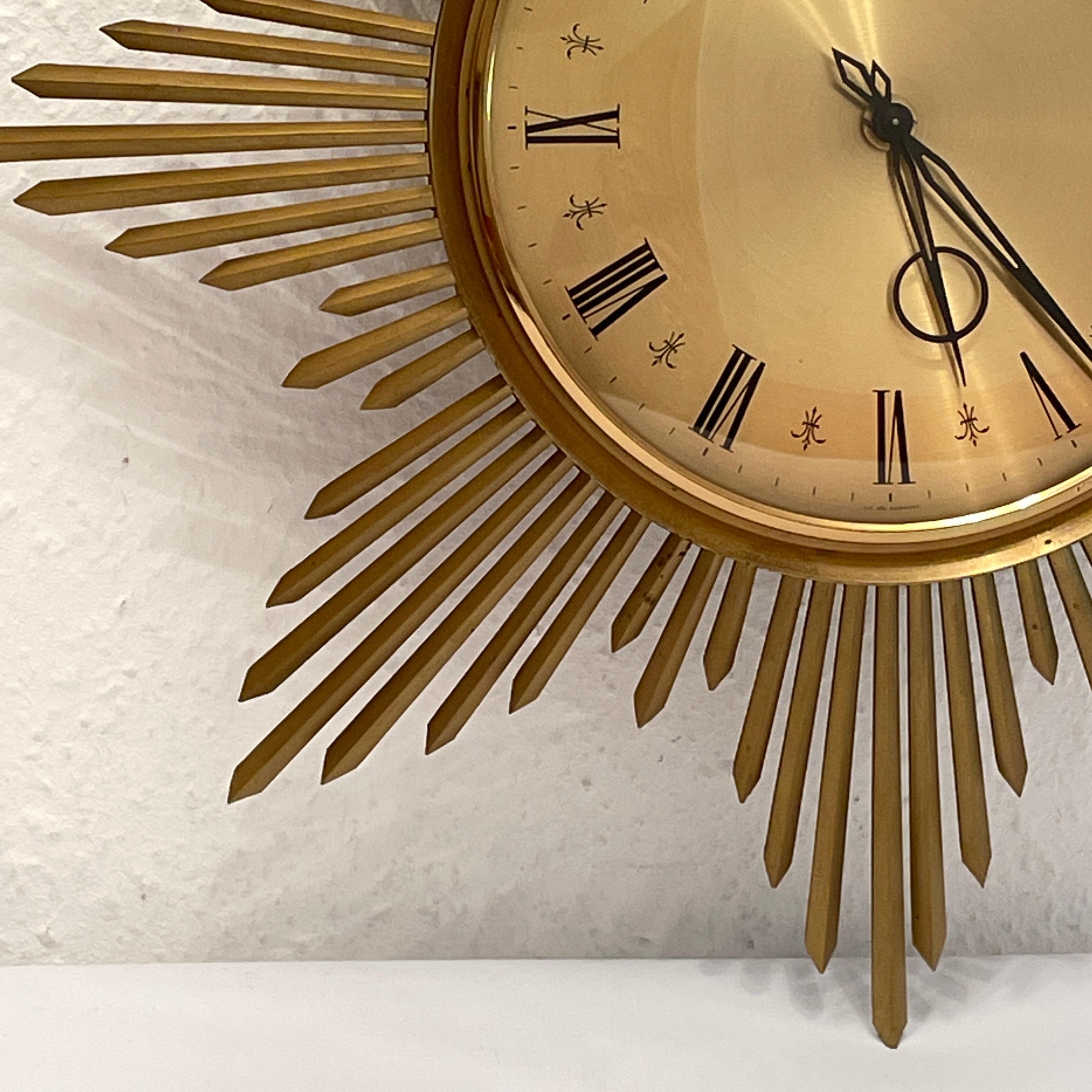 Stunning original 1960s Junghans ATO-MAT S sunburst starburst wall clock. Featuring beautiful brass sunburst surrounding illustrating perfectly the mood of the decade. The clock has the particularity of having an hinged face so hands can be accessed