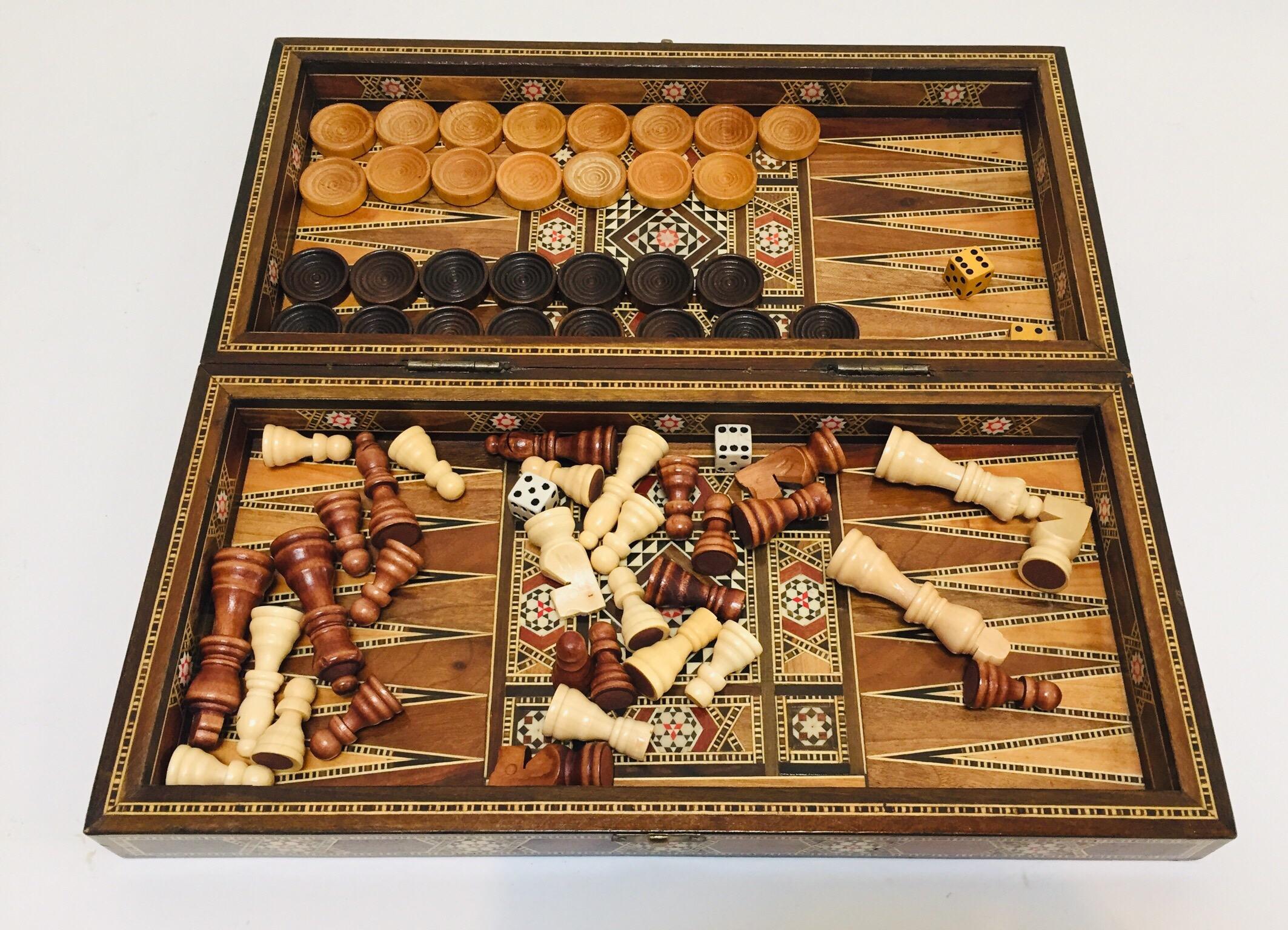 Large vintage midcentury Syrian inlaid with mother of pearl mosaic backgammon and chess game.
Great inlaid micro mosaic hinged marquetry game box features a chess and checker board on the exterior and backgammon board on the interior with all the