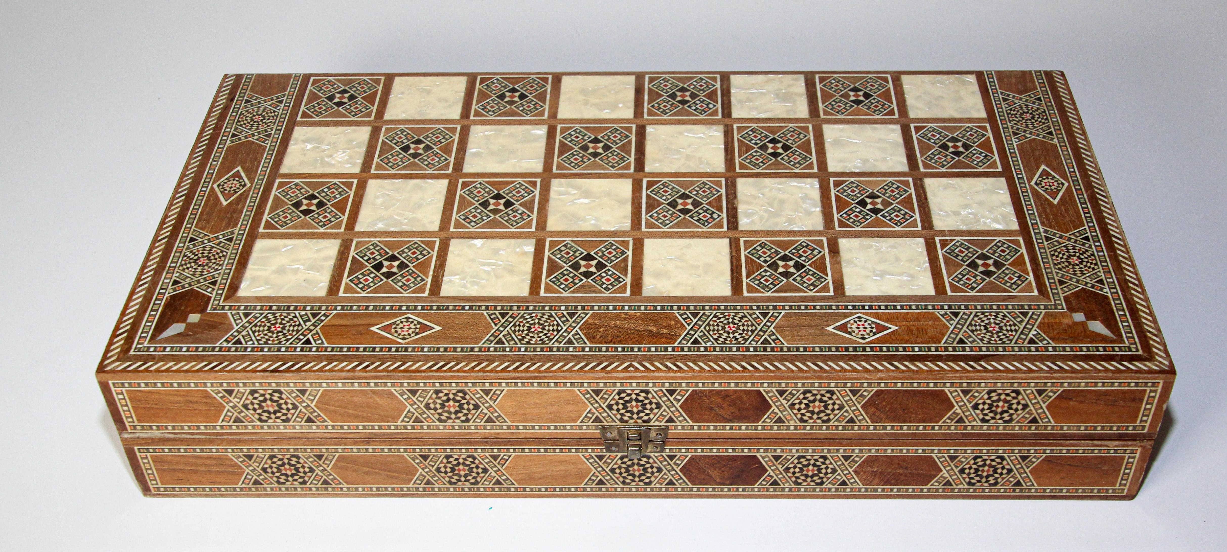 Large vintage midcentury Syrian inlaid with mother of pearl mosaic backgammon and chess game.
Great inlaid micro mosaic amarquetry game box features a chess and checker board on the exterior and backgammon board on the interior with all the wooden