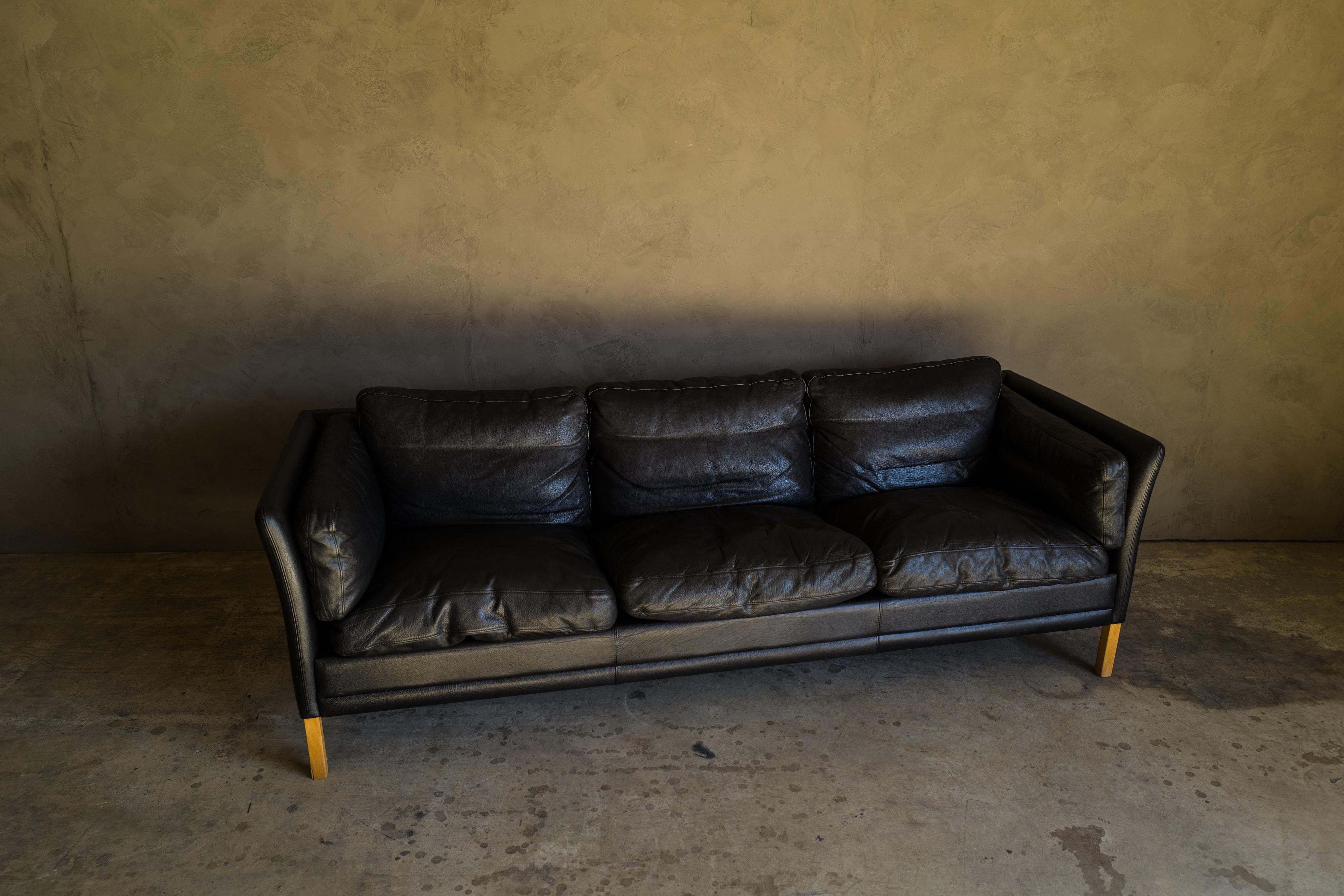 Vintage midcentury leather sofa from Denmark, circa 1980. Original black leather upholstery with light patina and wear.