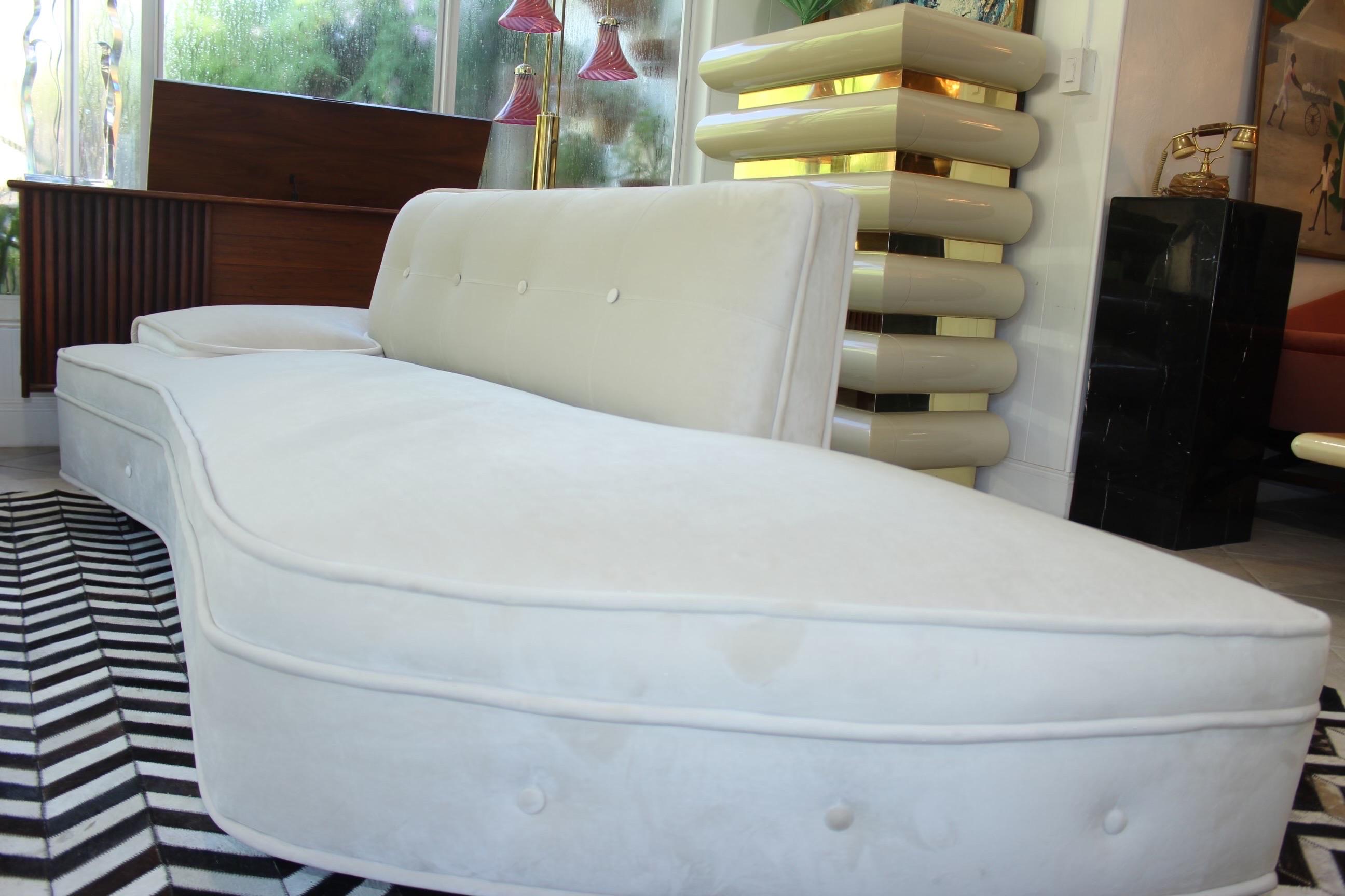 Vintage Midcentury Modern sofa newly reupholstered with performance high quality ivory velvet. Classic 1950’s rounded end on one side and one arm attached throw pillow on the other. Special care was taken to keep original structure/design with