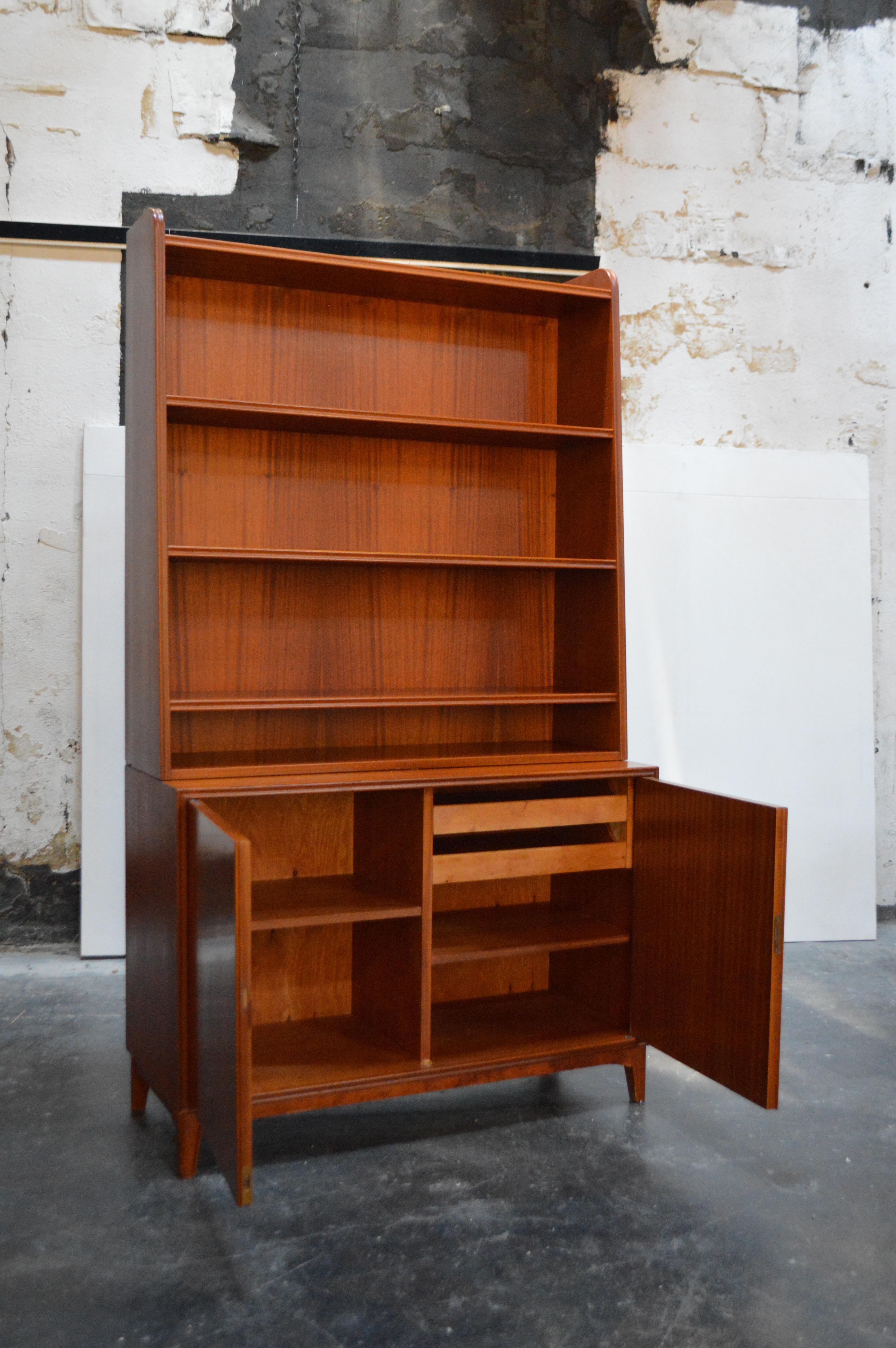 Beautiful Mid-Century Modern ribbon mahogany hutch manufactured by Brantorps in Sweden. The top shelving unit can be separated from the bottom cabinet/cupboard piece. 

Measures: Shelves: 11 D x 39.5 W x 41.5 H
Cabinet: 15.75 D x 39.5 W x 27.5