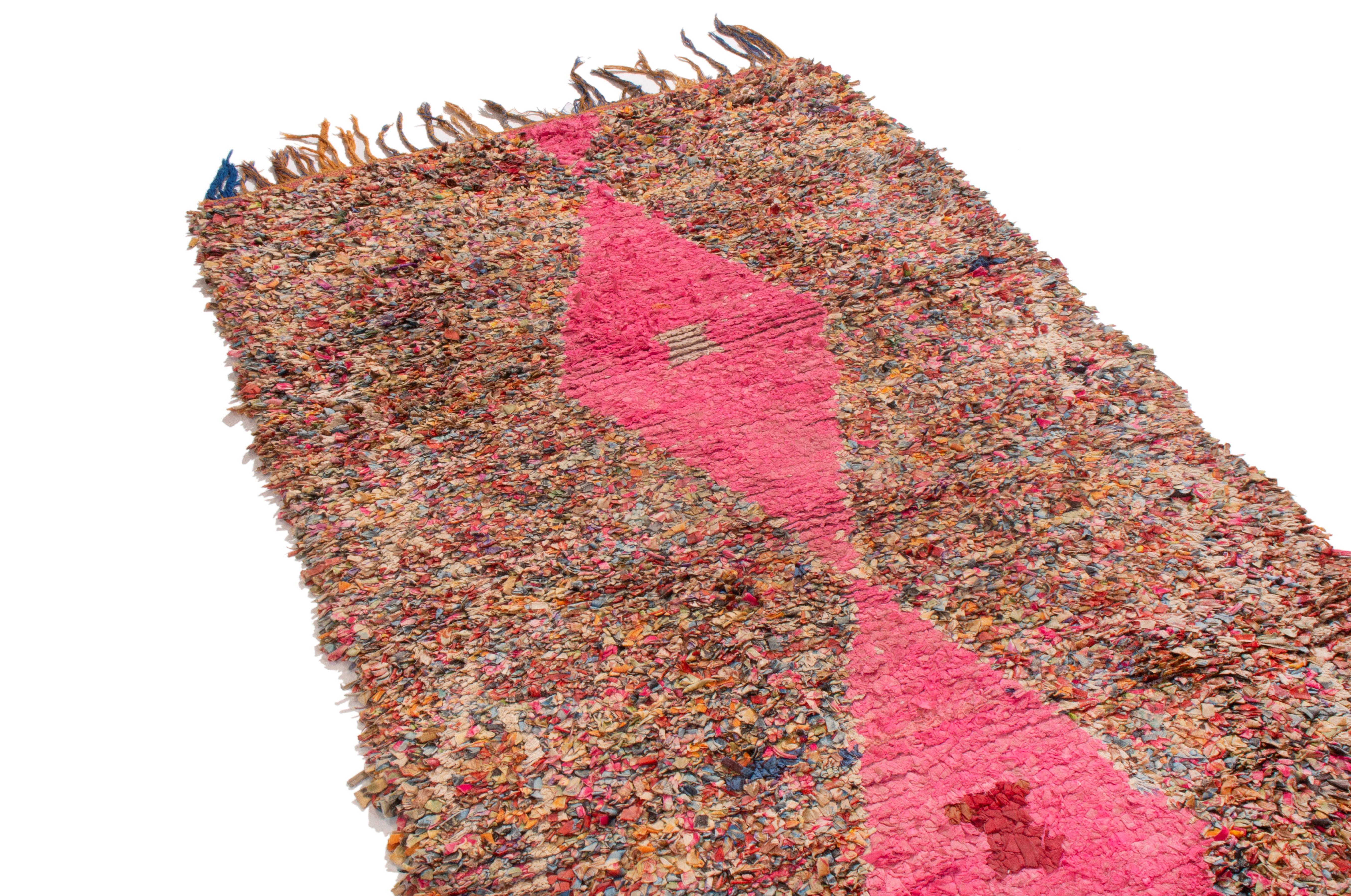 Originating from Morocco in 1950, this vintage midcentury Moroccan Berber rug has a combination of both distinct and subtle symbolism with particularly unique colorways. Hand knotted in durable wool, the eye-catching hot pink lozenges symbolizing