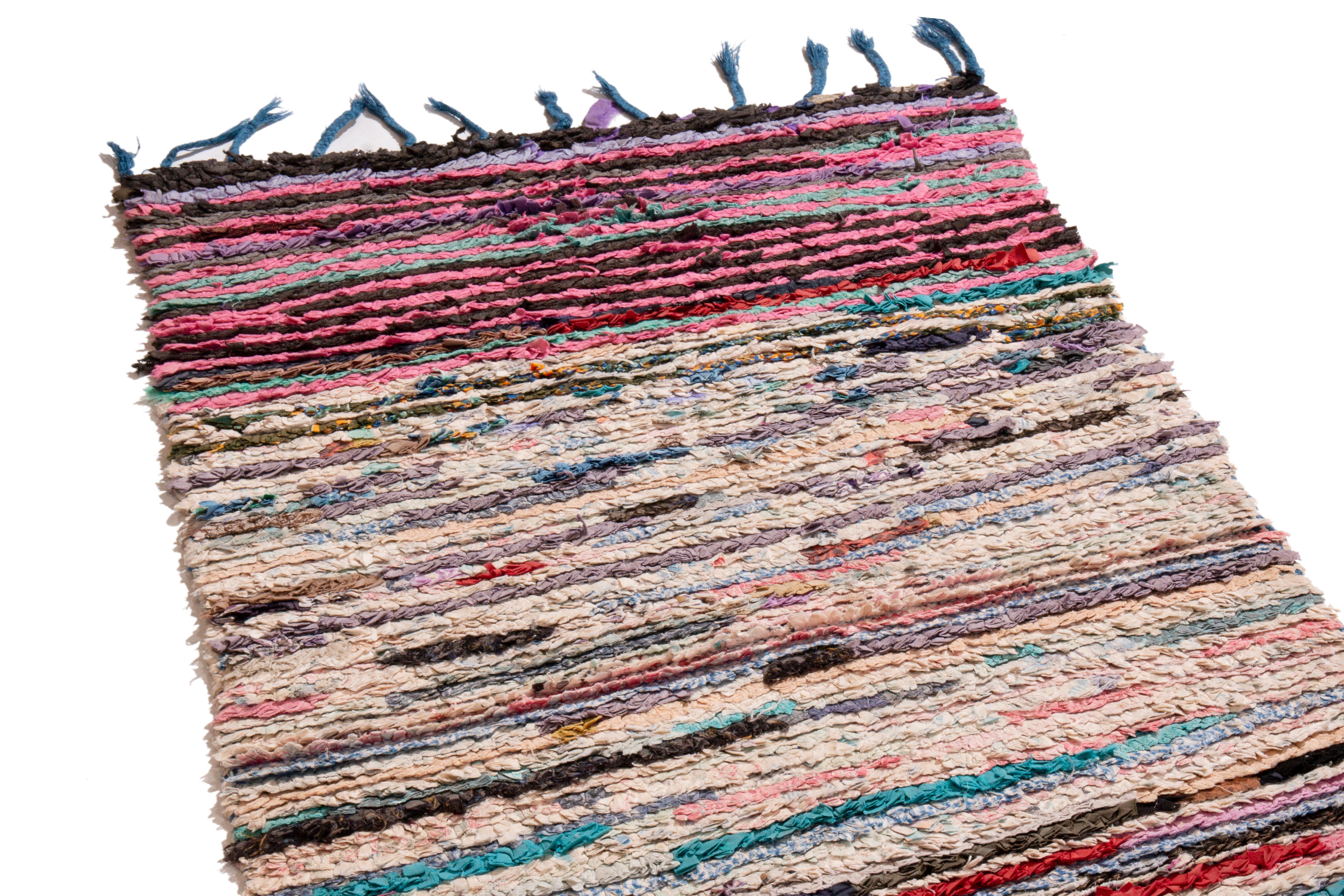 Originating from Morocco in 1950, this vintage mid-century Moroccan wool runner employs a unique distribution of color ways. Hand knotted in high quality wool, the all-over field design creates a distinguished visual gravity in the concentration of