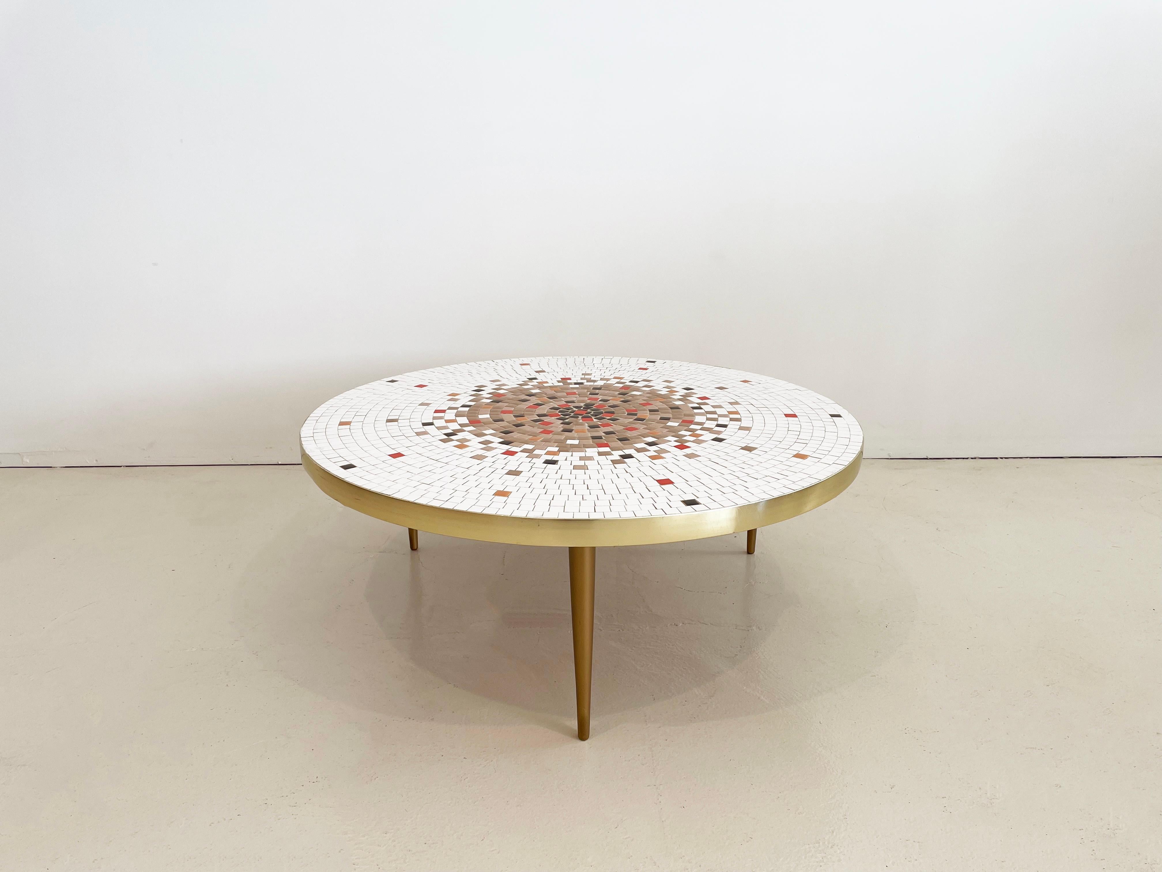 Moderner Couchtisch aus der Mitte des Jahrhunderts mit Mosaikfliesen und Messingzierleisten und -beinen.

Das Mosaikmuster besteht aus elfenbeinfarbenen, zwei warmen hellen Brauntönen, einem satten dunklen Espressobraun, Mandarinenorange und