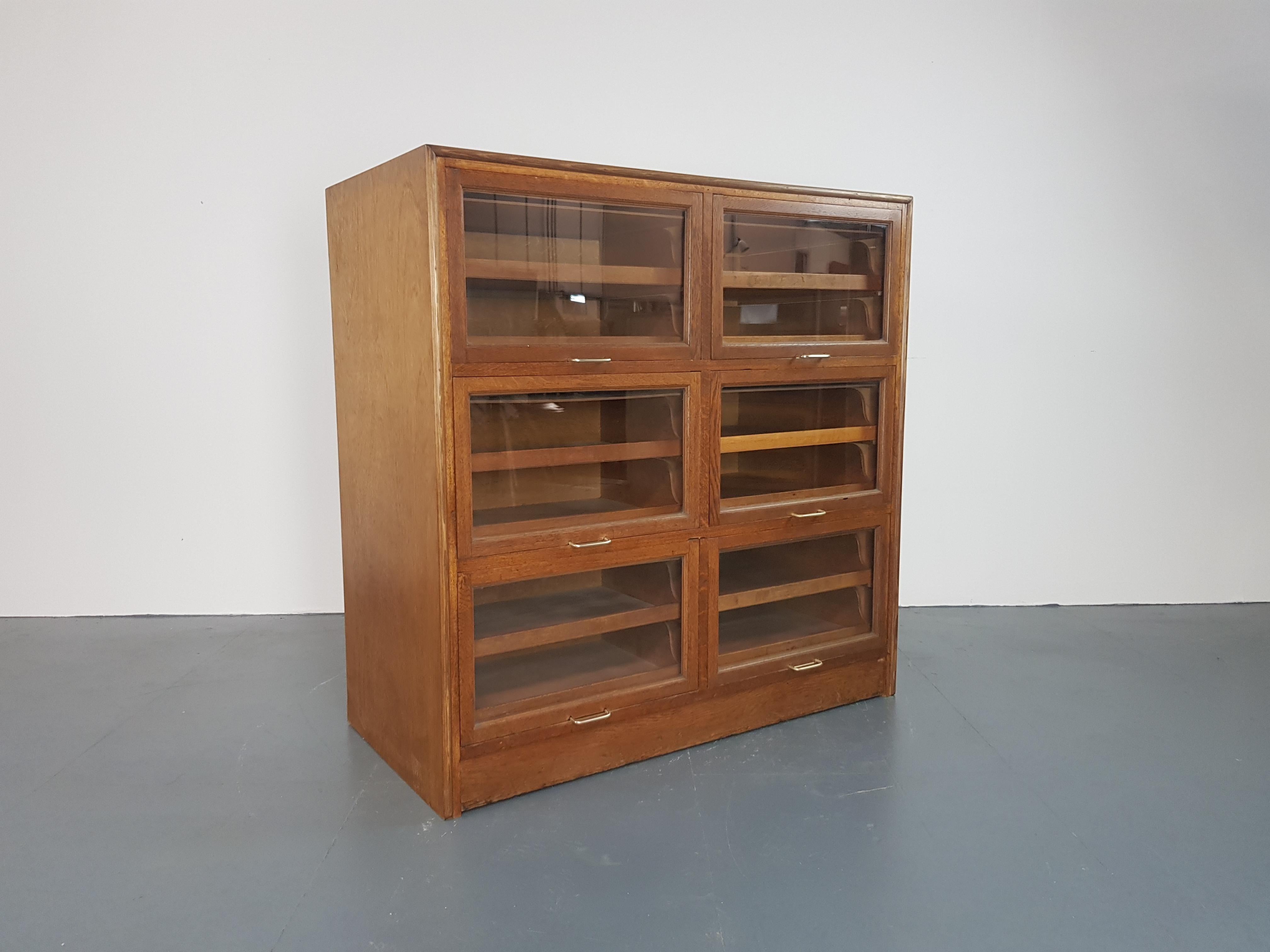 Very lovely 6-section haberdashery cabinet from the early part of the last century.  Each section has glass fronted up and over doors, with 2 pull out wooden drawers in each.  
In good vintage condition. Some scuffs here and there, as to be