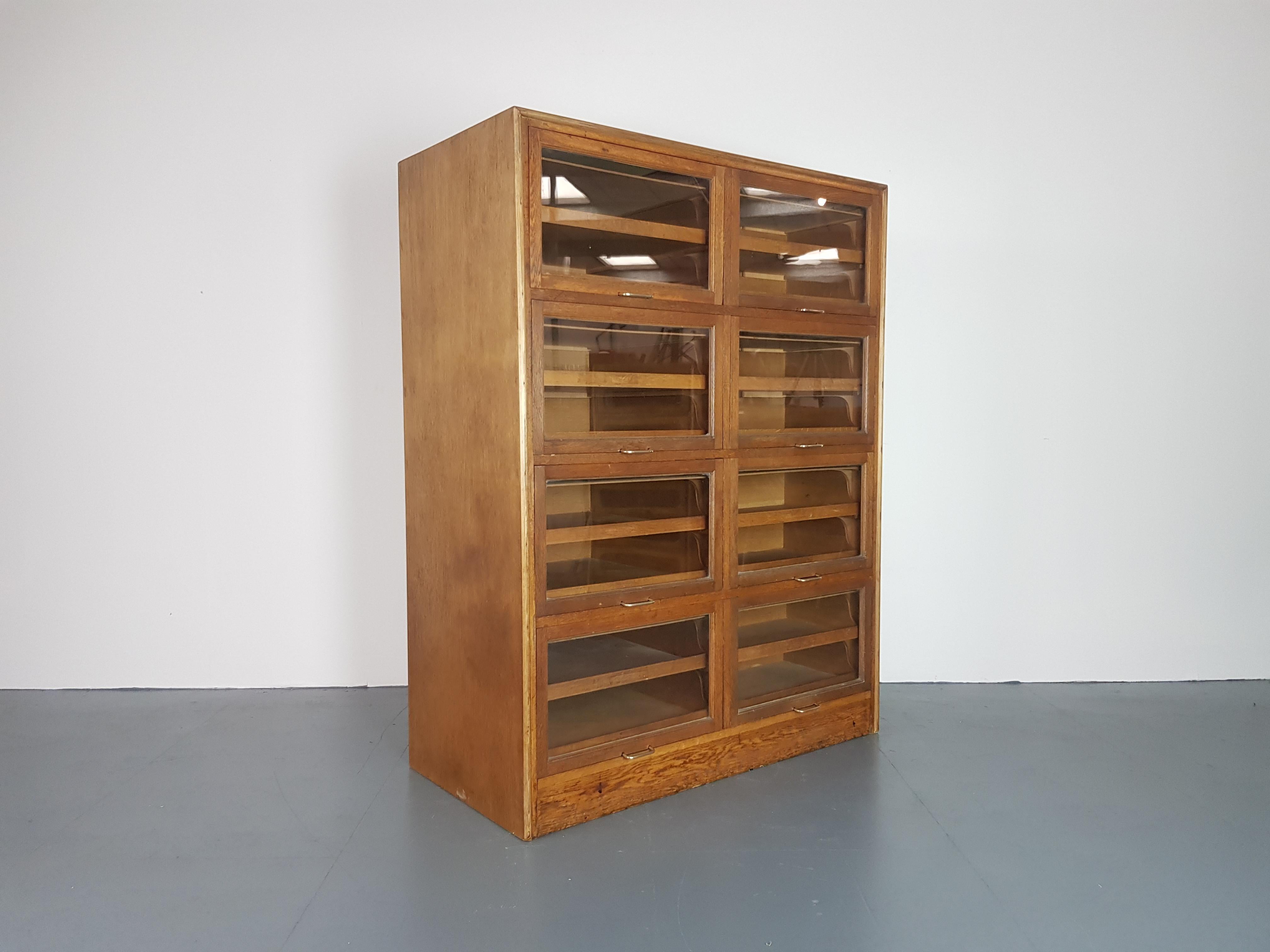 Very lovely 8 section haberdashery cabinet from the early part of the last century.  Each section has glass fronted up and over doors, with 2 pull out wooden drawers in each.  
In good vintage condition. Some scuffs here and there, as to be