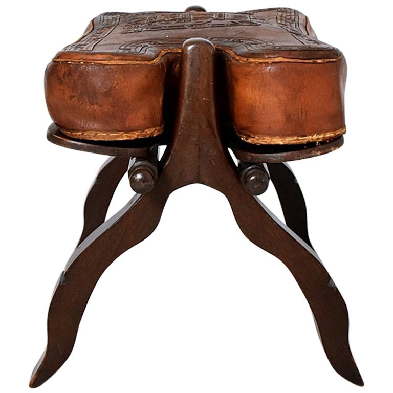 Vintage Peruvian ottoman /stool with original leather upholstery. Sophisticated design with a solid sculpture frame and leather upholstery, can be disassembled for easy transport and versatility. Beautiful solid wood grains and shape. In very good