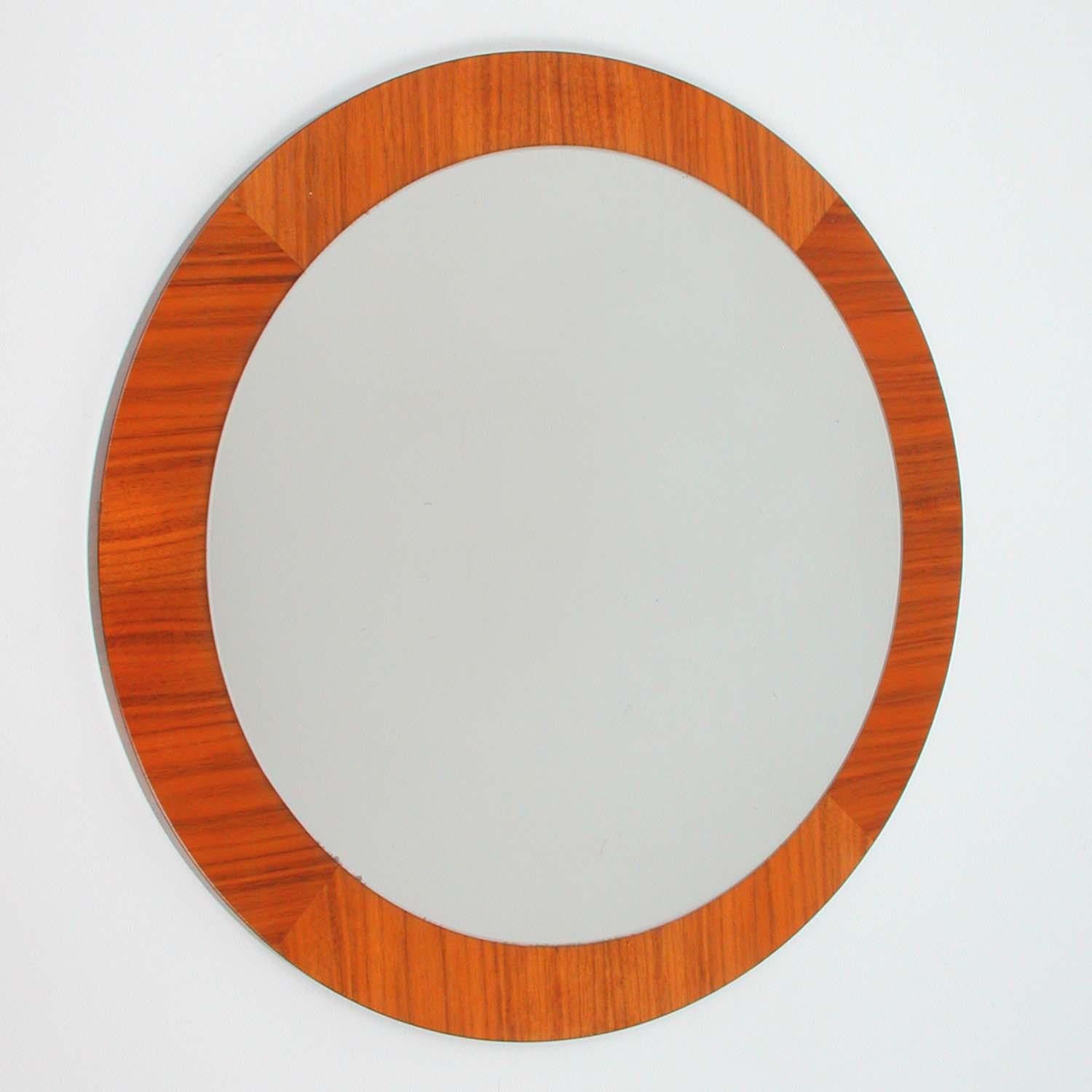 This vintage round wall mirror was designed and manufactured in Denmark in the mid-century era. It features a teak frame and mirror glass.

Measures: Total diameter is 19.7