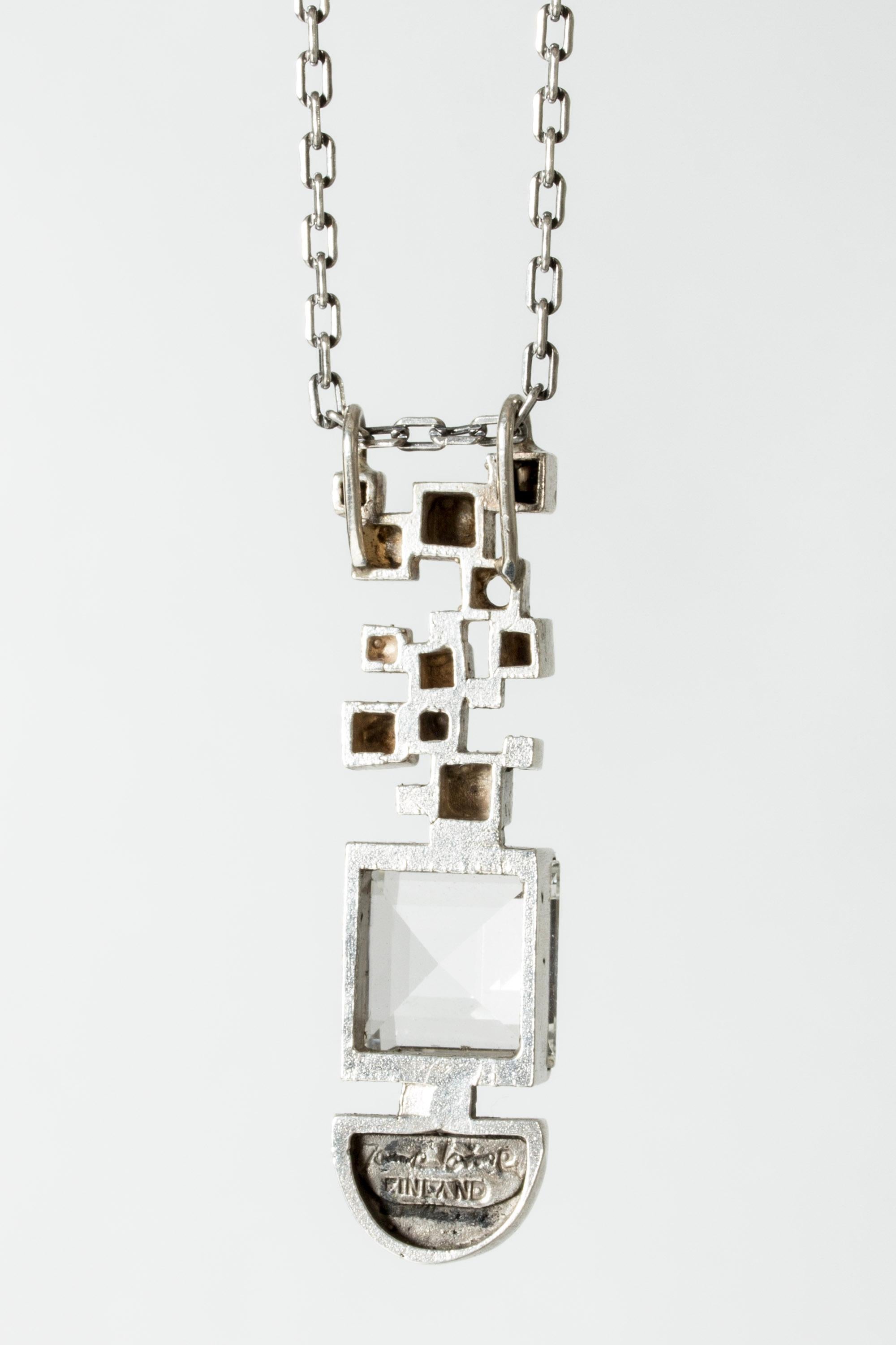 Beautiful silver pendant by Jorma Laine, in a long form with a square rock crystal and silver cubes. Imaginative, elegant design.

Jorma Laine was one of the most unique voices in the history of Scandinavian jewelry, and is considered one of the