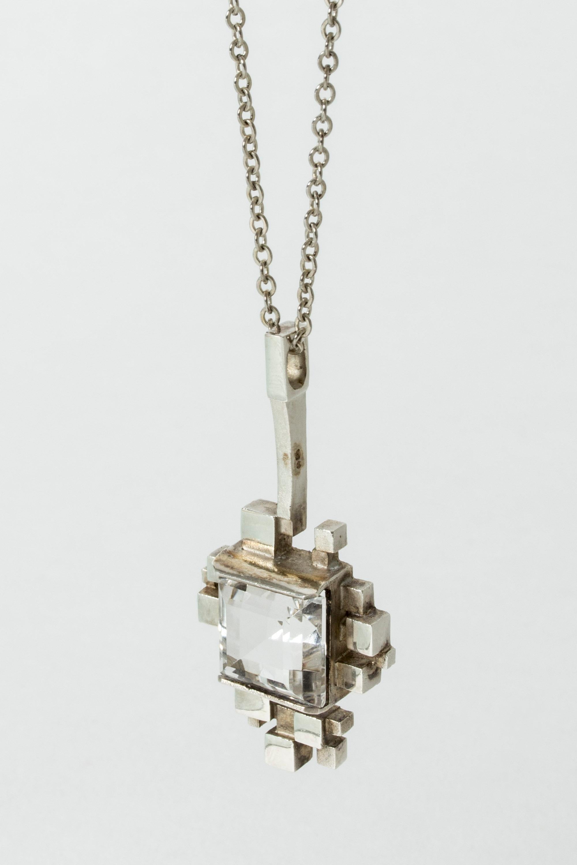 Beautiful silver pendant by Jorma Laine, with a square rock crystal in an asymmetric frame of silver cubes. A wonderful design, eye-catching design.

Height 5.4, width 2.5, depth 1 cm (pendant), length 48 cm (chain)