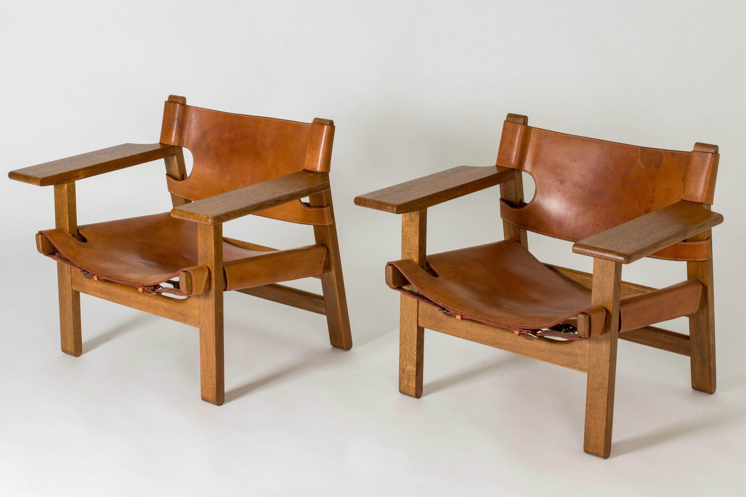 Pair of iconic oak and cognac leather “Spanish Chair” lounge chairs by Børge Mogensen. Mogensen got his inspiration for this design from a trip to Spain in 1958, where he came across a type of traditional chair which he then interpreted in a