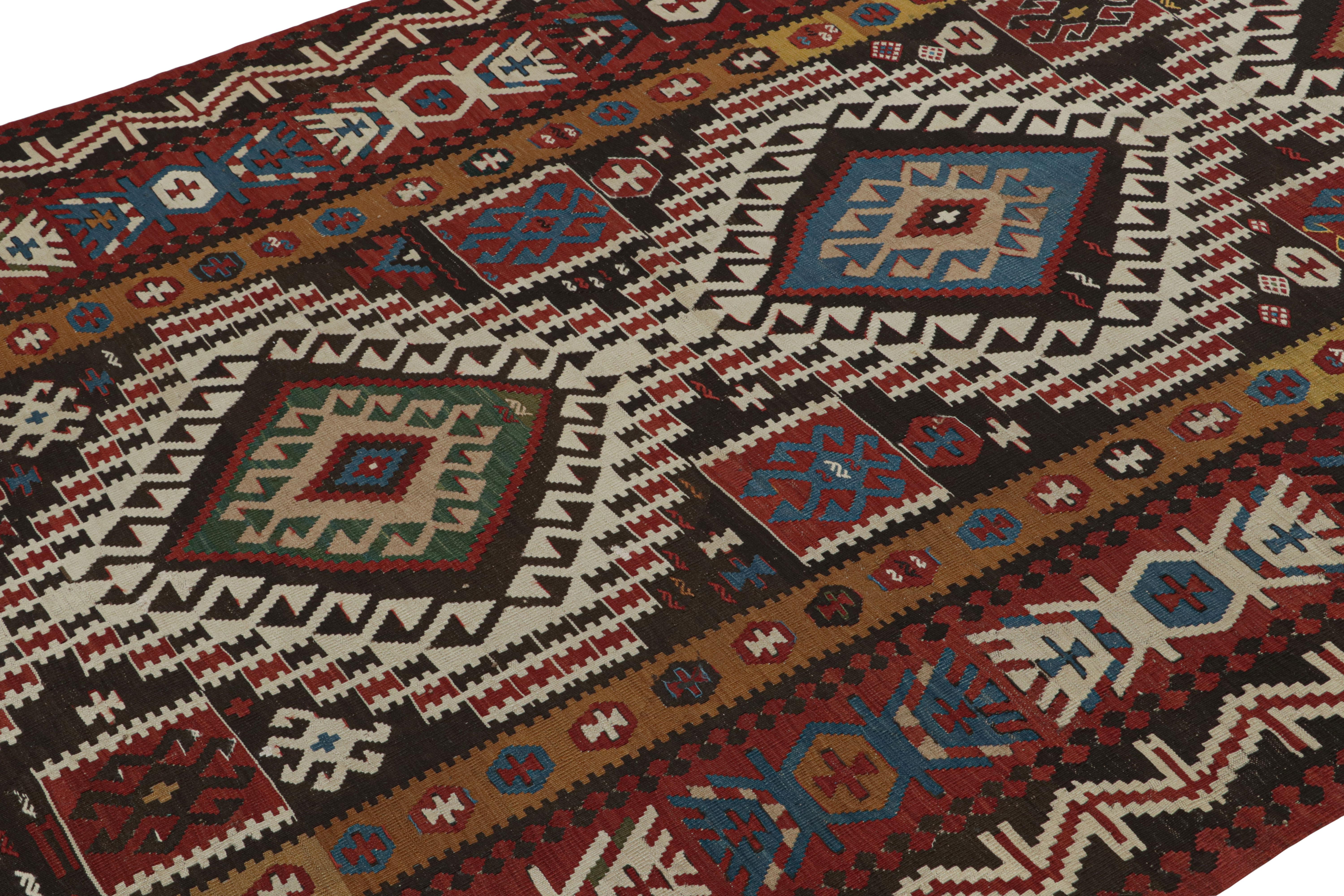 Handwoven in Turkey originating between 1950-1960, this vintage midcentury 6’ x 10’ wool Kilim features a design remniscent of the Surakhani region of neighboring Azerbaijan, enjoying an acclaimed traditional tribal geometric diamond pattern with