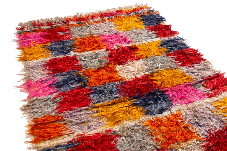 Originating from Turkey in 1950, this vintage midcentury wool rug employs a Classic Tulu design with its own distinguishing geometric element. Hand knotted in especially thick wool pile, Tulu rugs were known for Minimalist colors and texturally