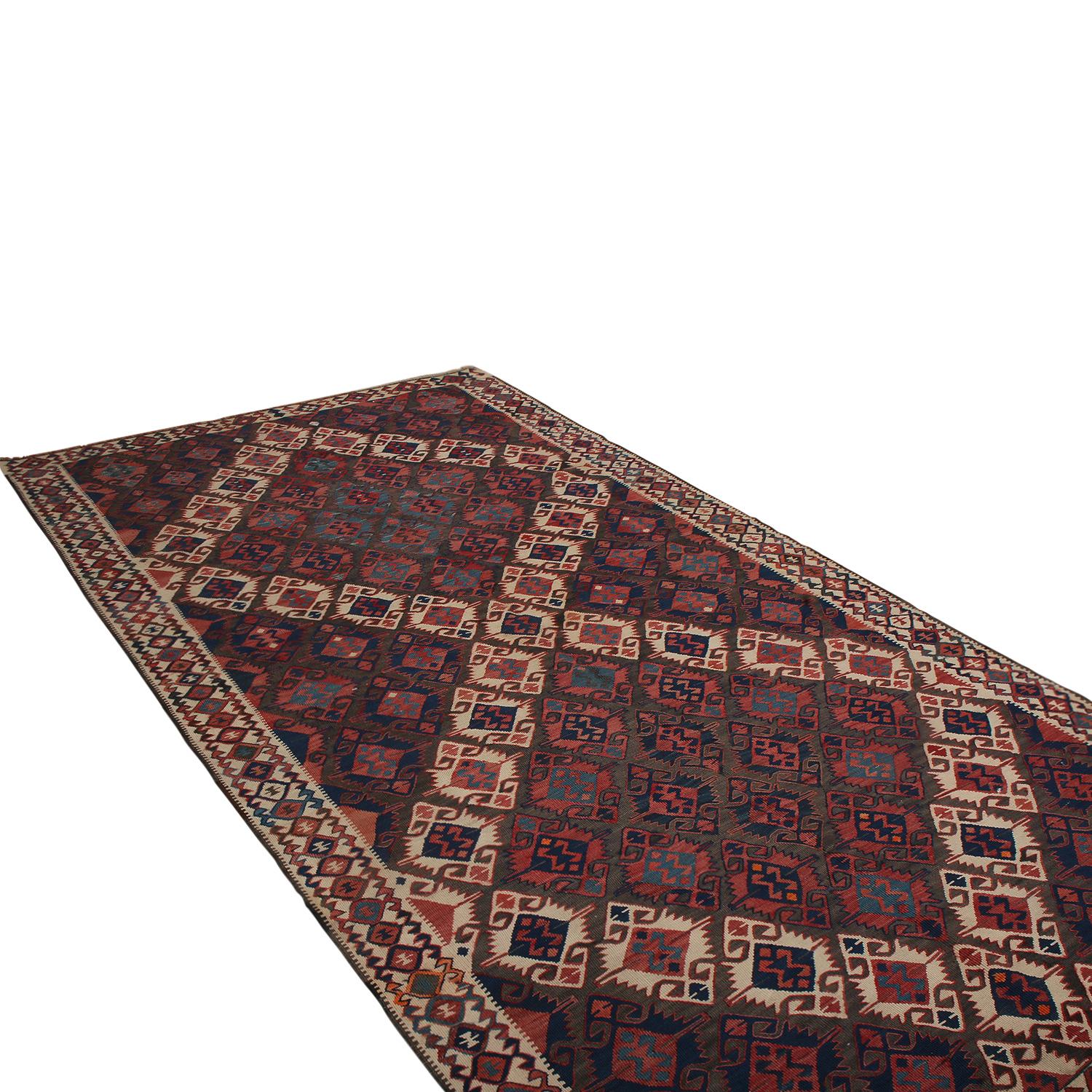 Flat-woven in Turkey originating between 1950-1960, this vintage midcentury geometric Kilim hails from the city of Van, enjoying a gripping tribal contrast of its rich burgundy red and beige-brown hues in its field and border, both accented by