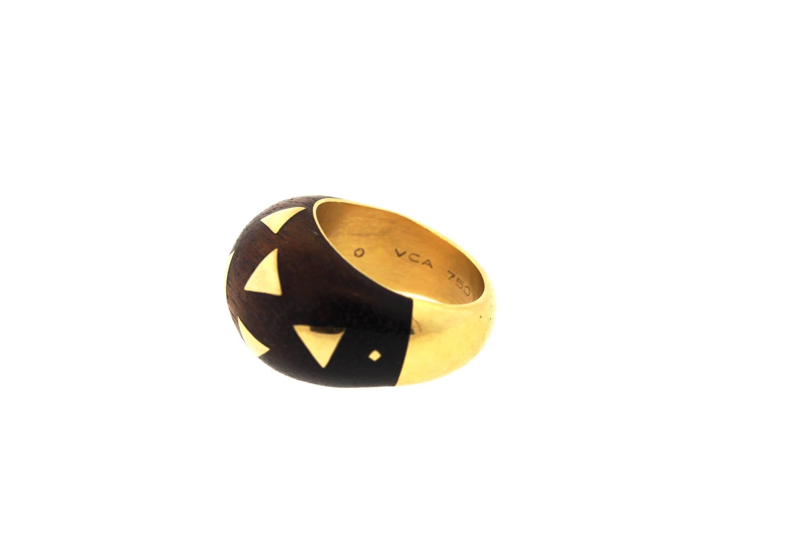 A fun wood and 18k gold bombe ring by Van Cleef & Arpels, circa 1960. The ring is made with a tan sandalwood, set with gold triangles. The ring has great texture and shape. It is signed VCA 750 B5867 B64. The ring is currently as size 6 and would be