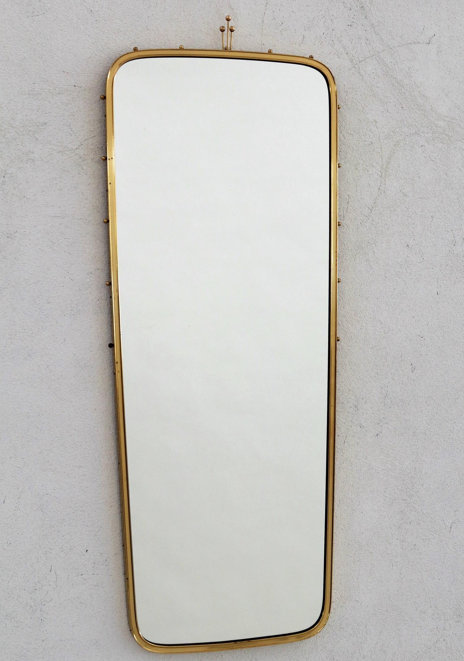 Elegant long crystal glass wall mirror with brass frame and nice brass details.
Made in the 1970s. Very good quality.
The mirror is in the original shape, no defects, but shows some normal vintage spots on the brass (see all pictures)
The long