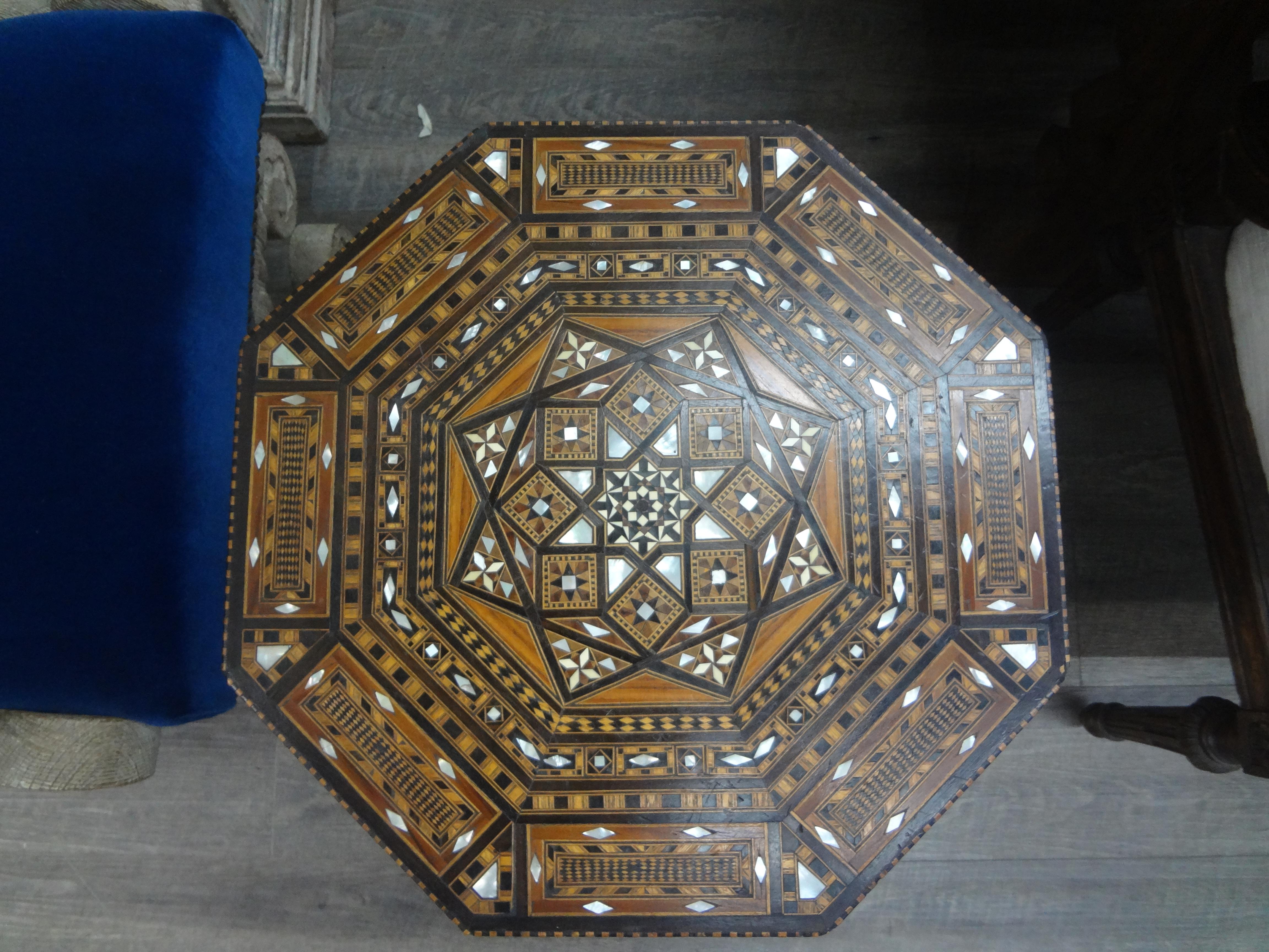 Vintage Middle Eastern Arabesque style Inlaid octagonal table.
This handsome middle eastern or Islamic Arabesque style octagonal table is inlaid with a variety of woods in a geometric pattern with mother of pearl accents. Great accent table, side