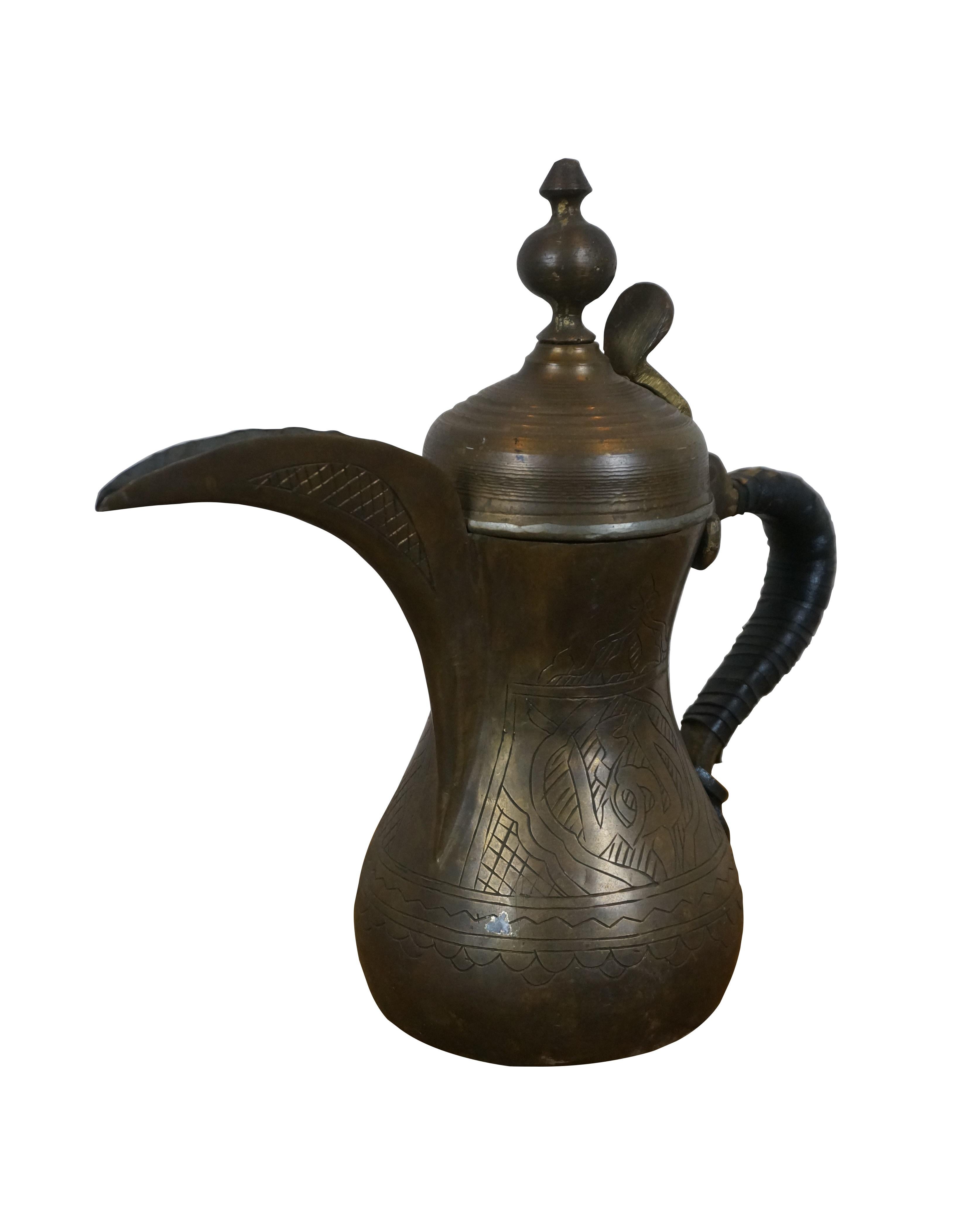 Antique Middle Eastern etched Arabic brass dallah / coffee pot with long spout, flip top lid, and two tone woven leather wrapped handle.

Dimensions:
12
