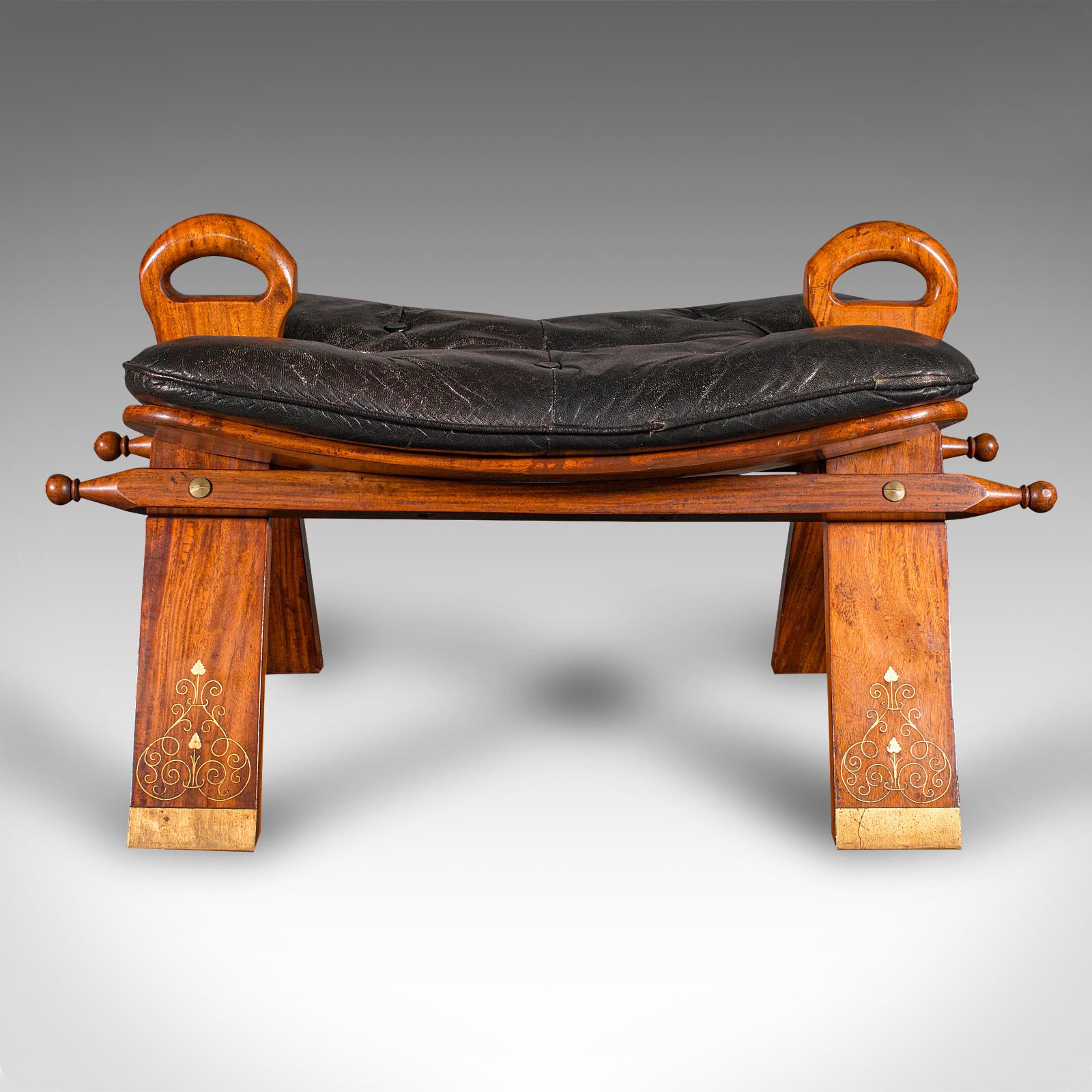 This is a charming Middle Eastern camel seat, dating to the mid 20th century, circa 1960. This distinctive hallway shoe rest or occasional footstool showcases elegant craftsmanship, warm walnut tones, and brass inlay detail.

Unique A-frame design –
