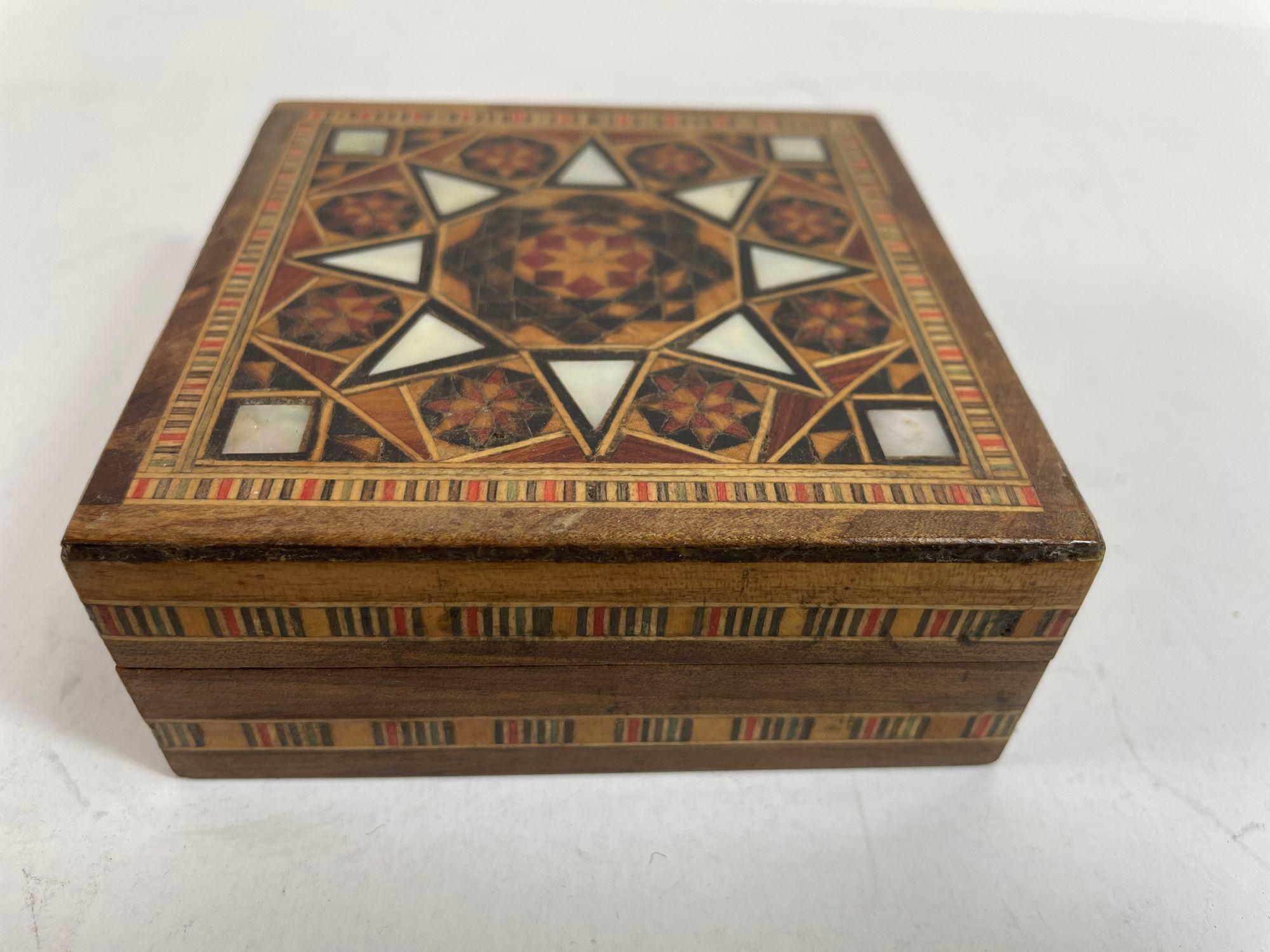 Vintage Middle Eastern Moorish Intarsien Mosaik Trinket Box.
Aufbewahrungsbox mit maurischen Intarsien aus dem Nahen Osten.
Die erstaunliche Handwerkskunst der Intarsienarbeit aus Obstholz mit maurischen geometrischen Mosaikmustern macht ihn zu