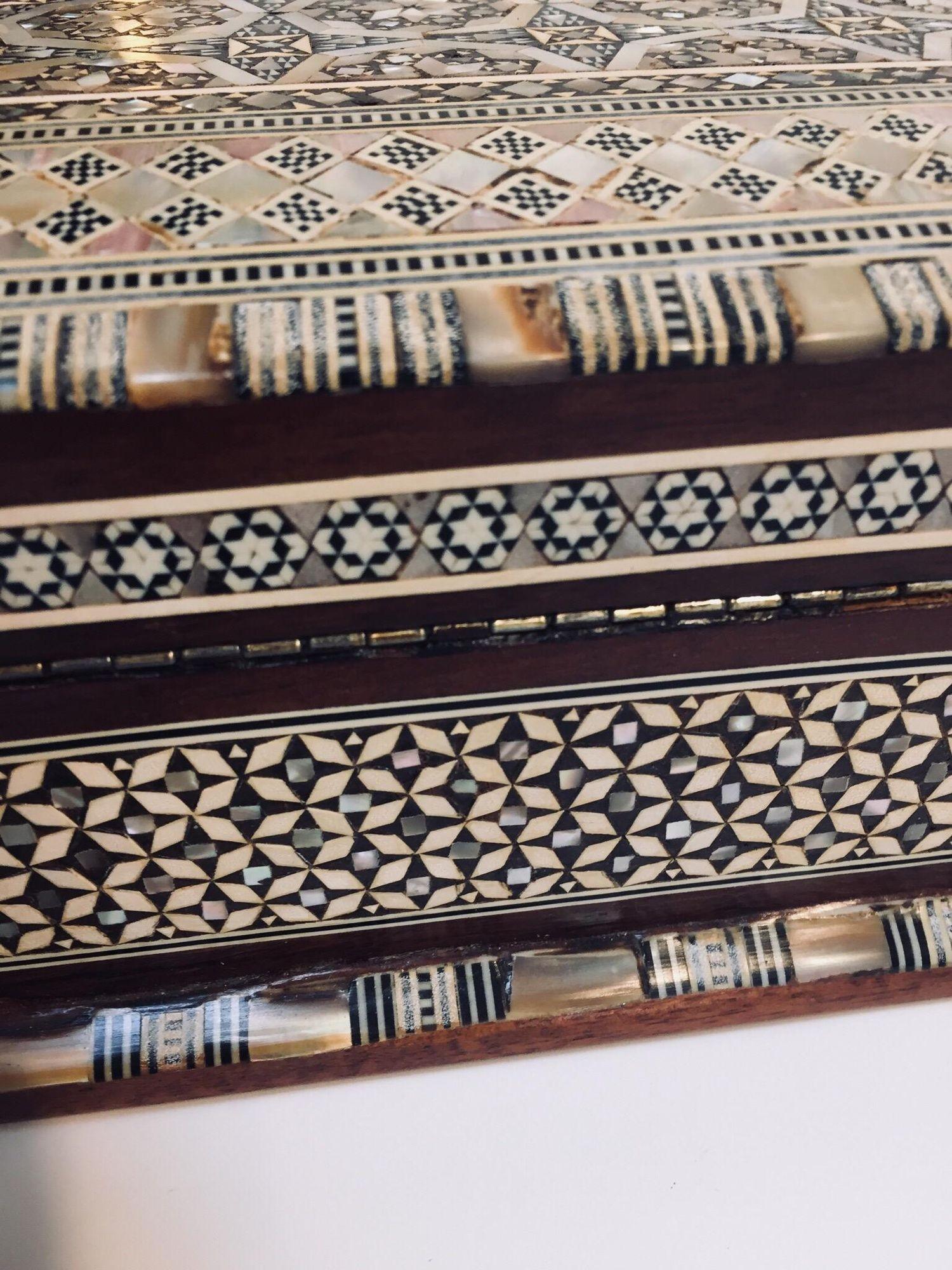 Boîte à bijoux vintage en bois mauresque du Moyen-Orient incrustée de marqueterie.
Boîte du Moyen-Orient fabriquée à la main en micro-mosaïques mauresques très fines, et un motif géométrique mauresque hexagonal et floral continu orne de façon