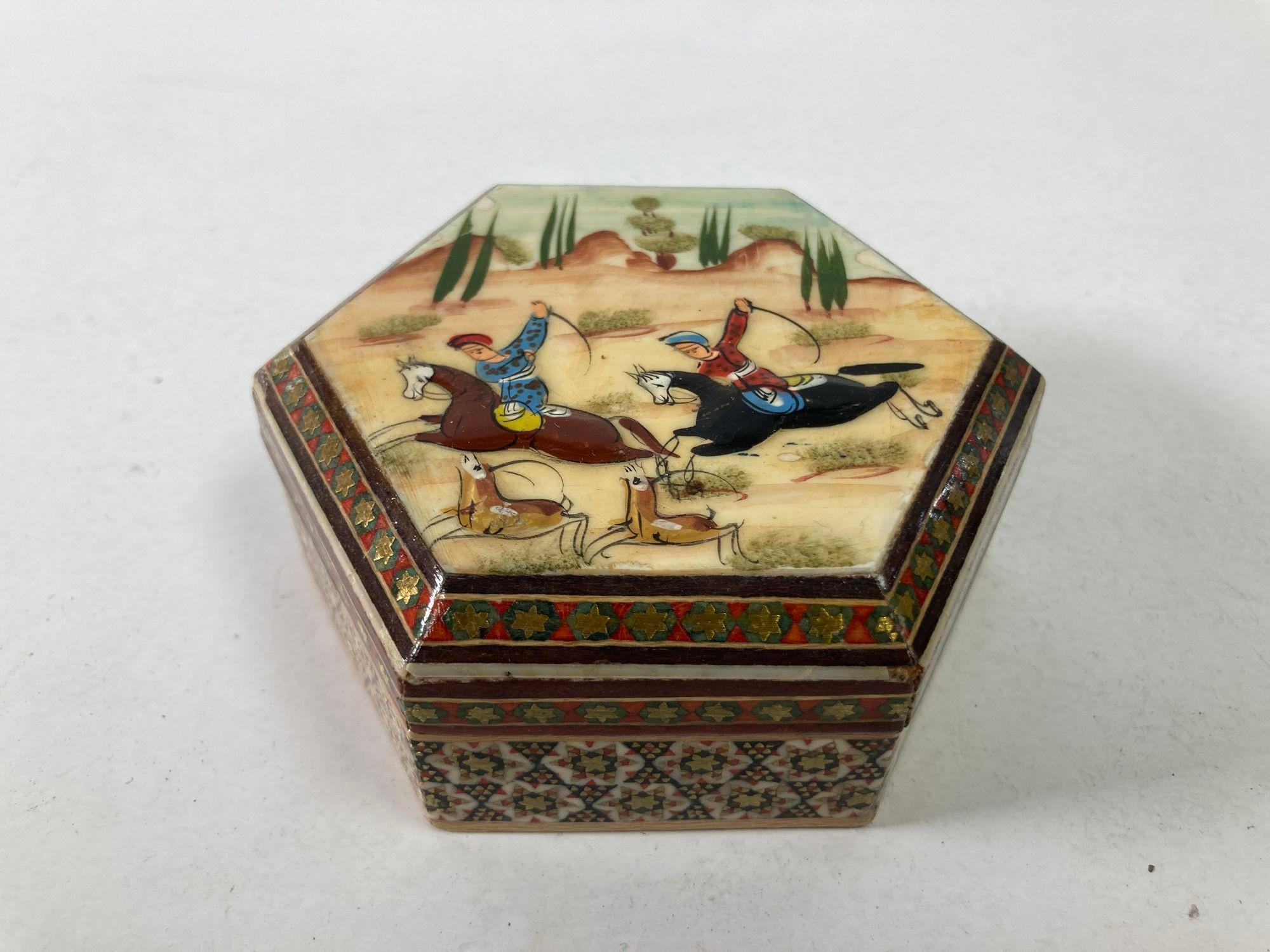 Vintage Middle Eastern Khatam Art Painting Miniature on hexagonal shape trinket box.
Boîte à tabac ou à bibelots en bois mauresque peint à la main et laqué, incrusté de micro-mosaïques.
Micro-mosaïque en marqueterie de bois indo-persane avec scène