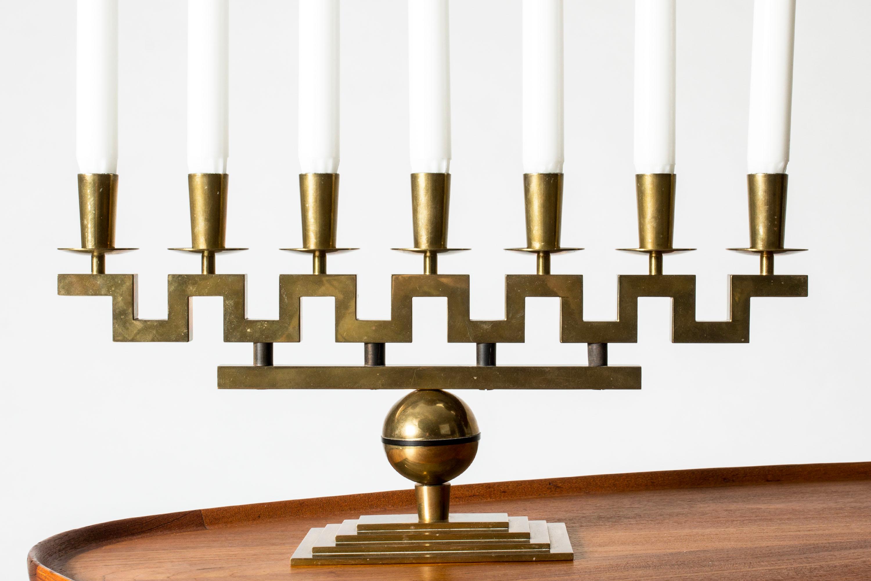 Incredibile candelabro in ottone di Lars Holmström, con un design geometrico a meandro e una base rettangolare. Contiene sette candele. Qualità pesante.