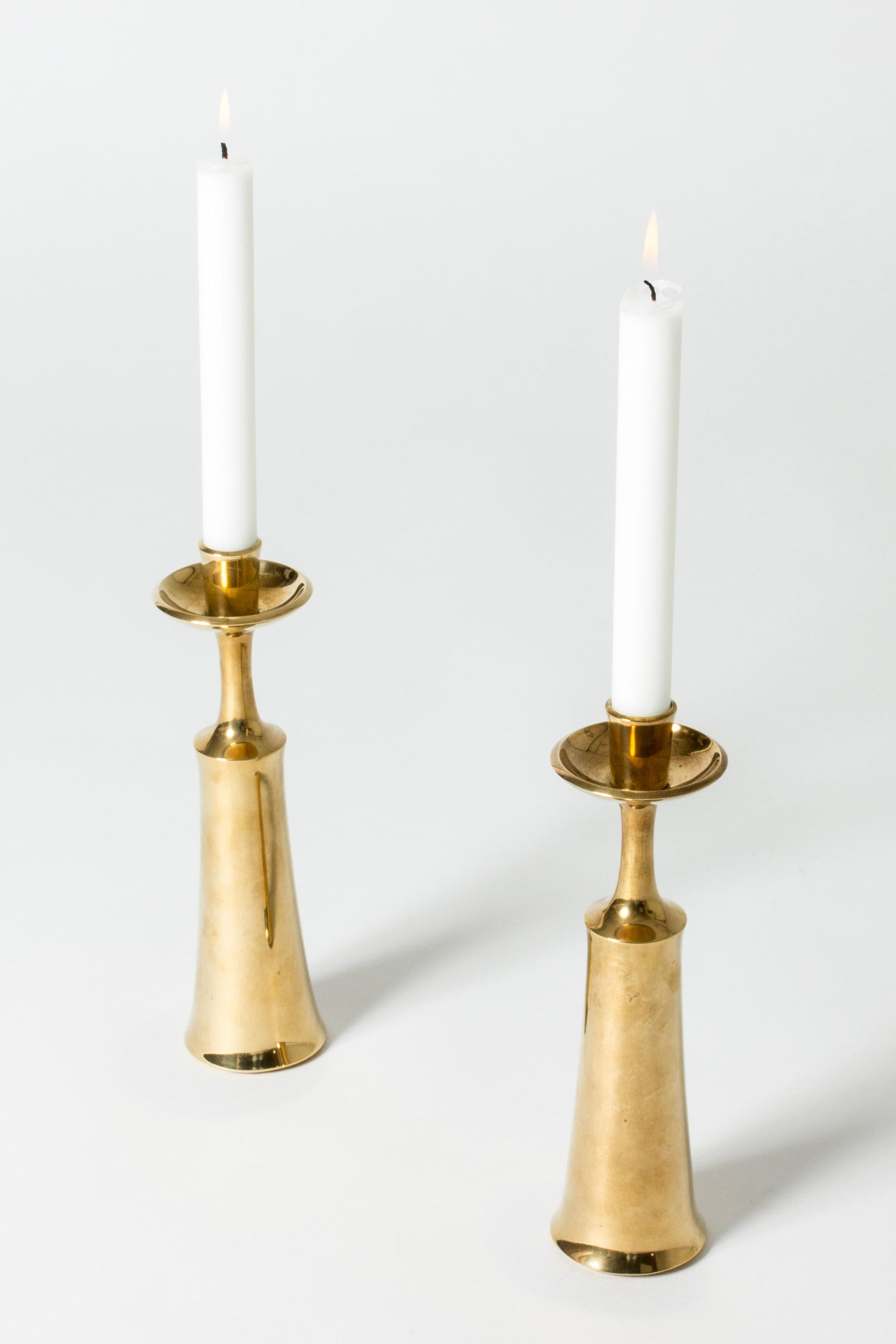 Pair of elegant brass candlesticks by Jens Quistgaard, in a sleek, tapering form.