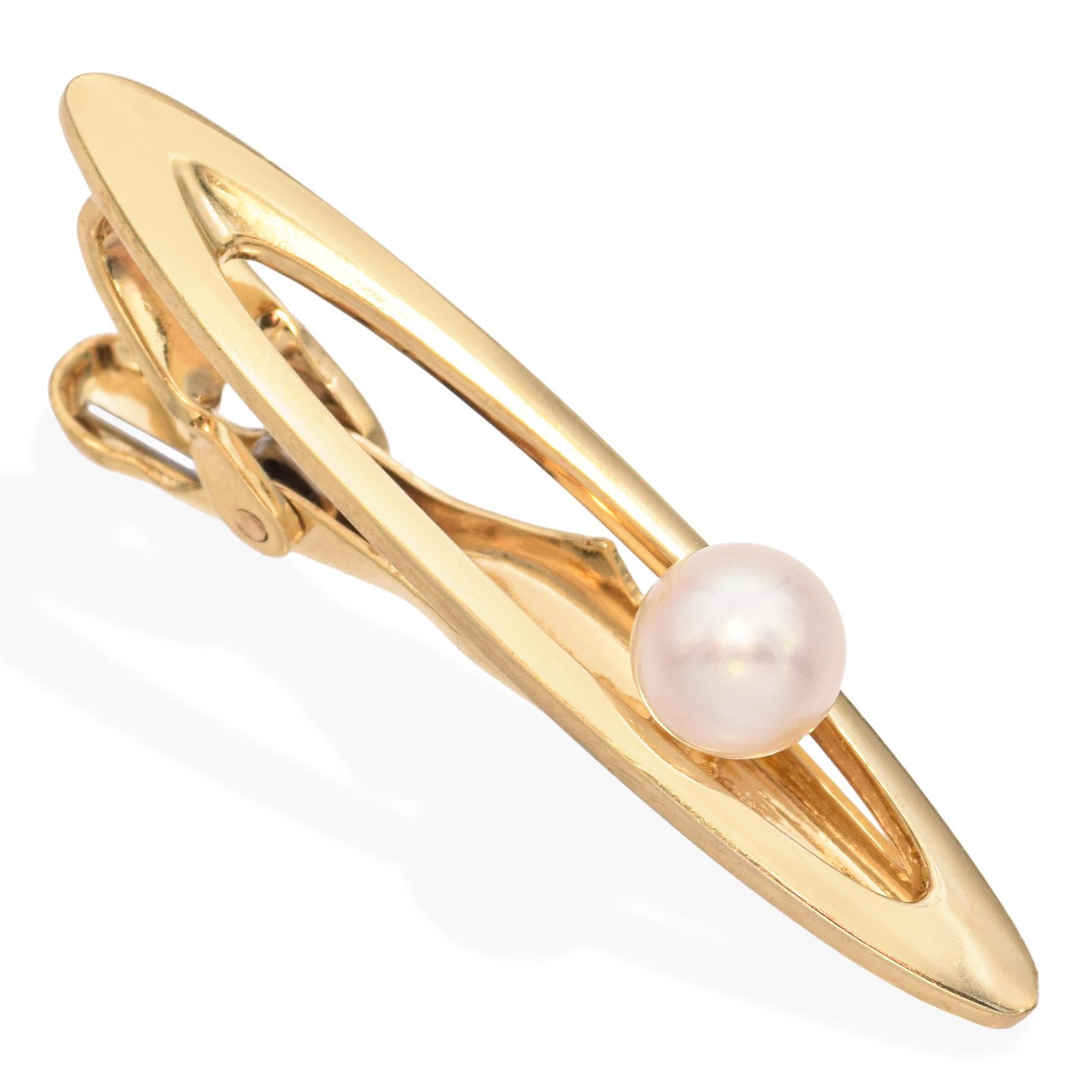 Diese Vintage-Krawattenklammer von K. Mikimoto Tokyo ist aus 14-karätigem Gelbgold gefertigt und mit einer einzelnen, leuchtenden Akoya-Perle versehen. Das minimalistische Design hebt die natürliche Schönheit und den sanften Glanz der Perle hervor,