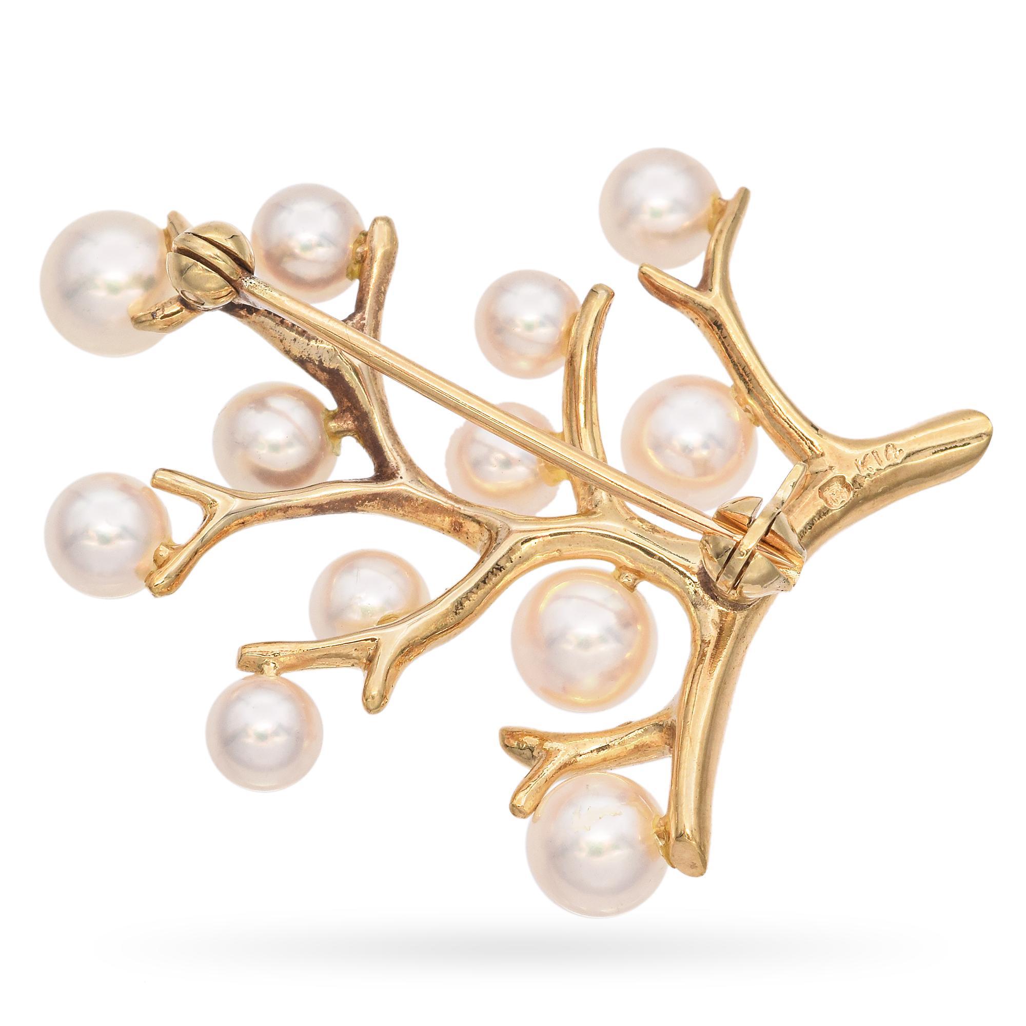 Elegant Mikimoto 14K Gold Pearl Brooch. This exquisite brooch is crafted in 14k gold. The design features lustrous white pearls arranged on a tree of life. Each pearl is meticulously placed, creating a harmonious and organic appearance. The brooch