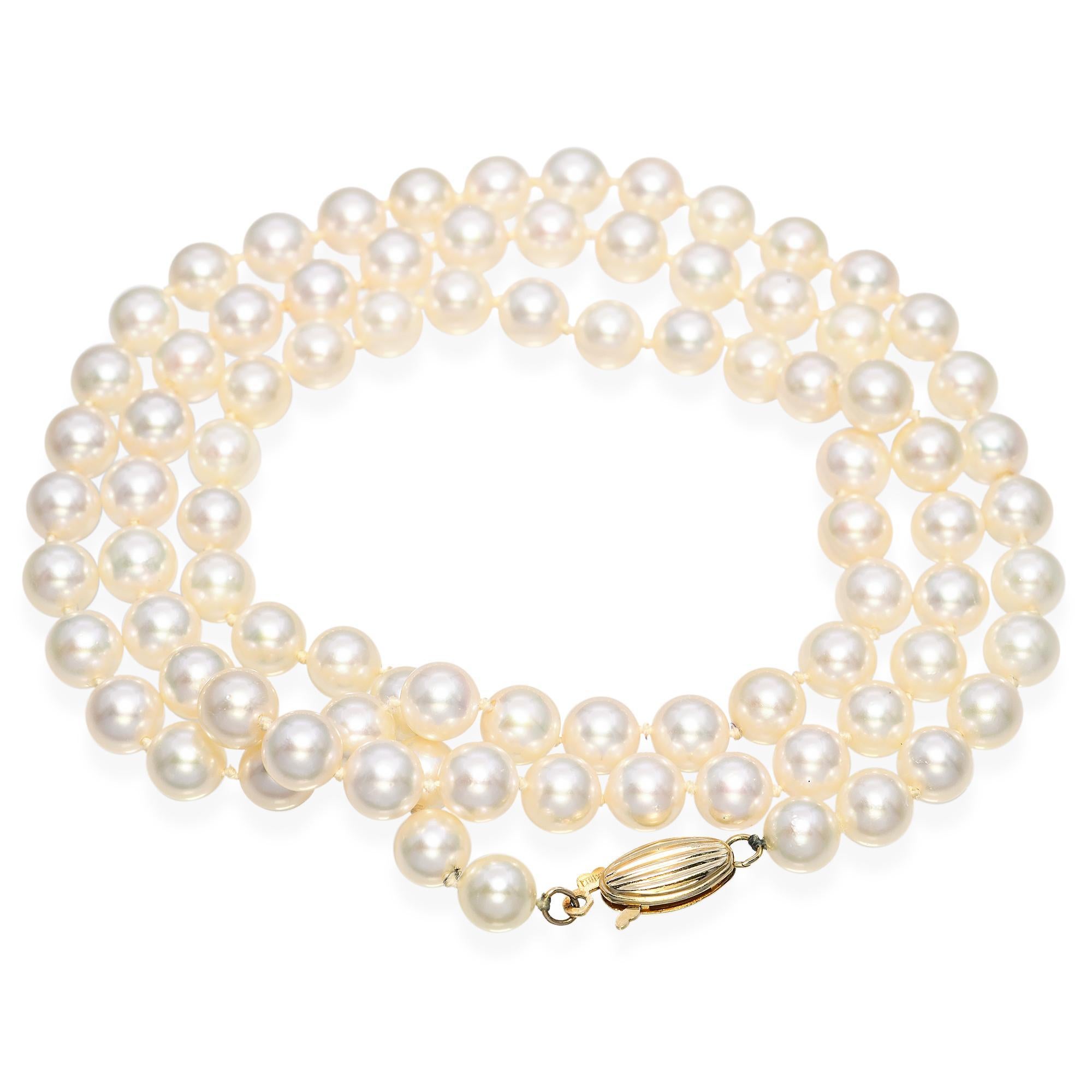 Un tesoro elegante e senza tempo di Mikimoto, la rinomata casa di perle coltivate. Questa collana vintage presenta un filo luminoso di perle Akoya pregiate, annodate singolarmente a mano e rifinite con una solida chiusura in oro giallo 14k con