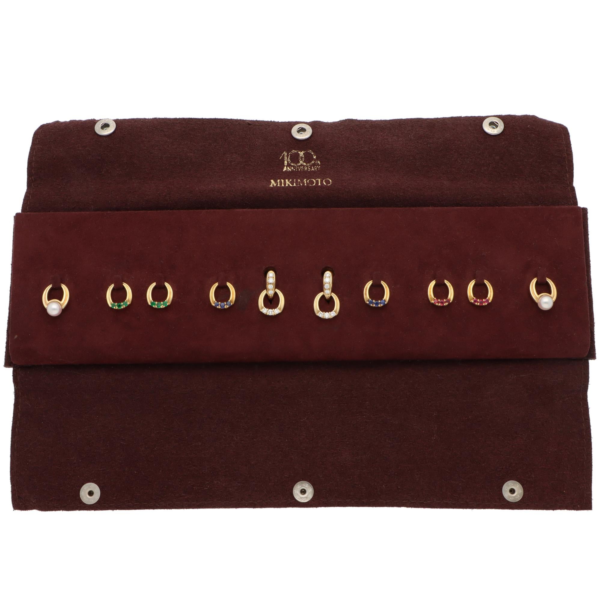 A unique pair of vintage Mikimoto 100th anniversary collection interchangeable drop earrings set in 18k yellow gold with diamond, ruby, sapphire, emerald and pearl, circa 1993.

Firstly, the set is composed of a pair of hoop earrings. Each earring