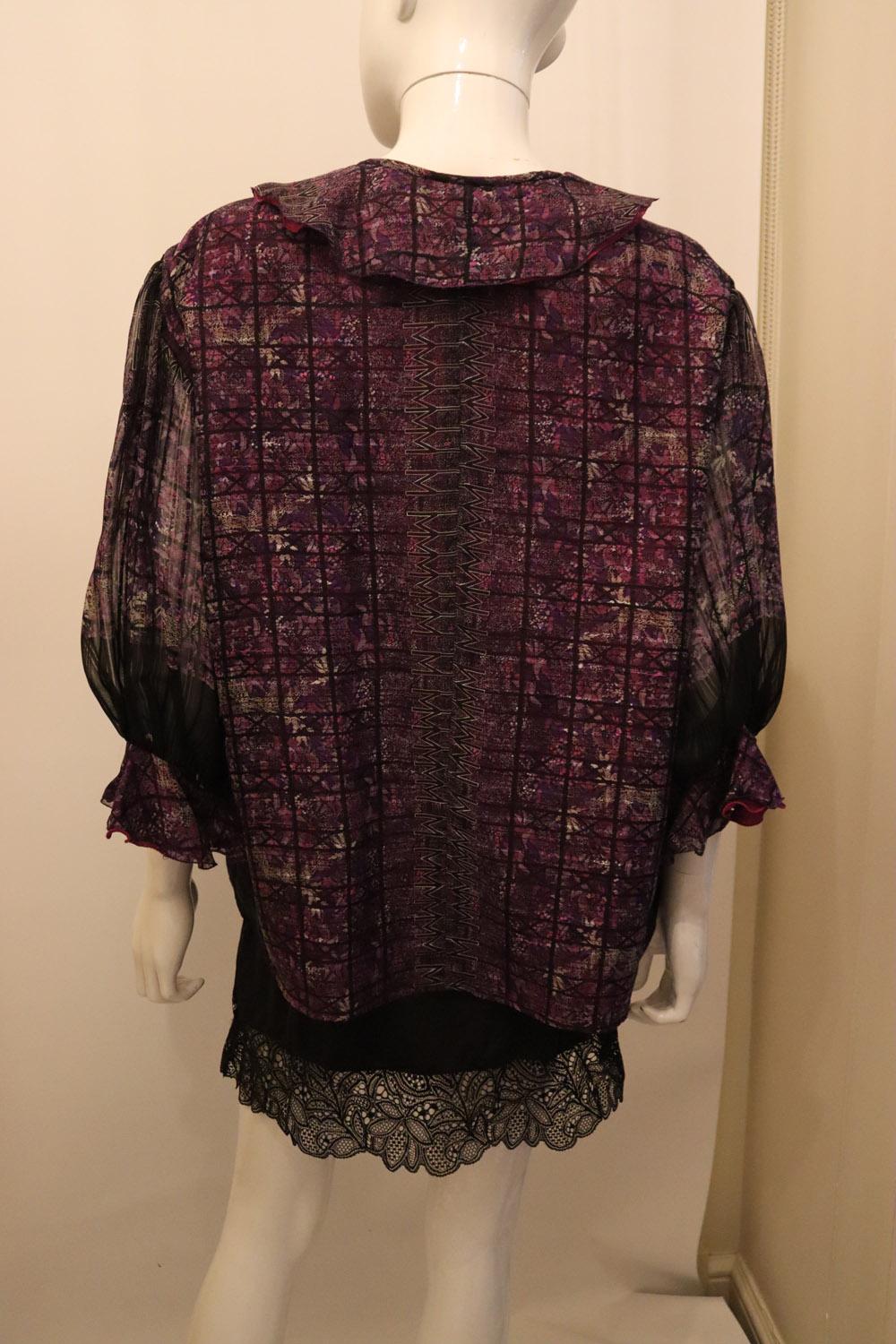 Un superbe chemisier en soie vintage de la marque italienne  la designer Mila Schon.  En soie violette  Avec une ouverture boutonnée sur le devant, le chemisier présente une rangée de deux volants sur les manches et l'encolure. Le chemisier est en
