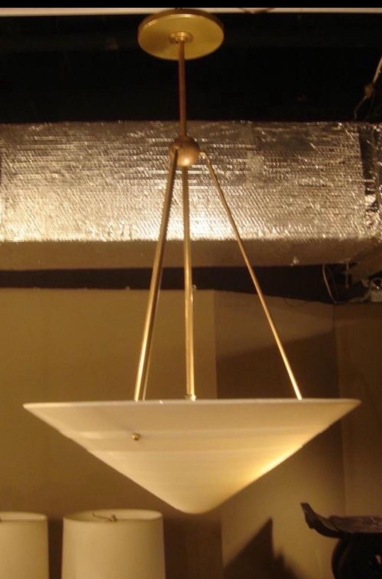 A vintage milk glass and brass hanging light fixture. Features a vintage glass shade suspended from a custom brass rod frame.

Shade is vintage; circa 1940.  Brass hanging frame may be customized.

Glass shade measures 19