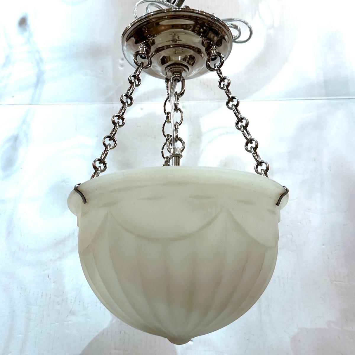 A circa 1920's English milk glass light fixture with three interior lights. 

Measurements:
Drop: 14