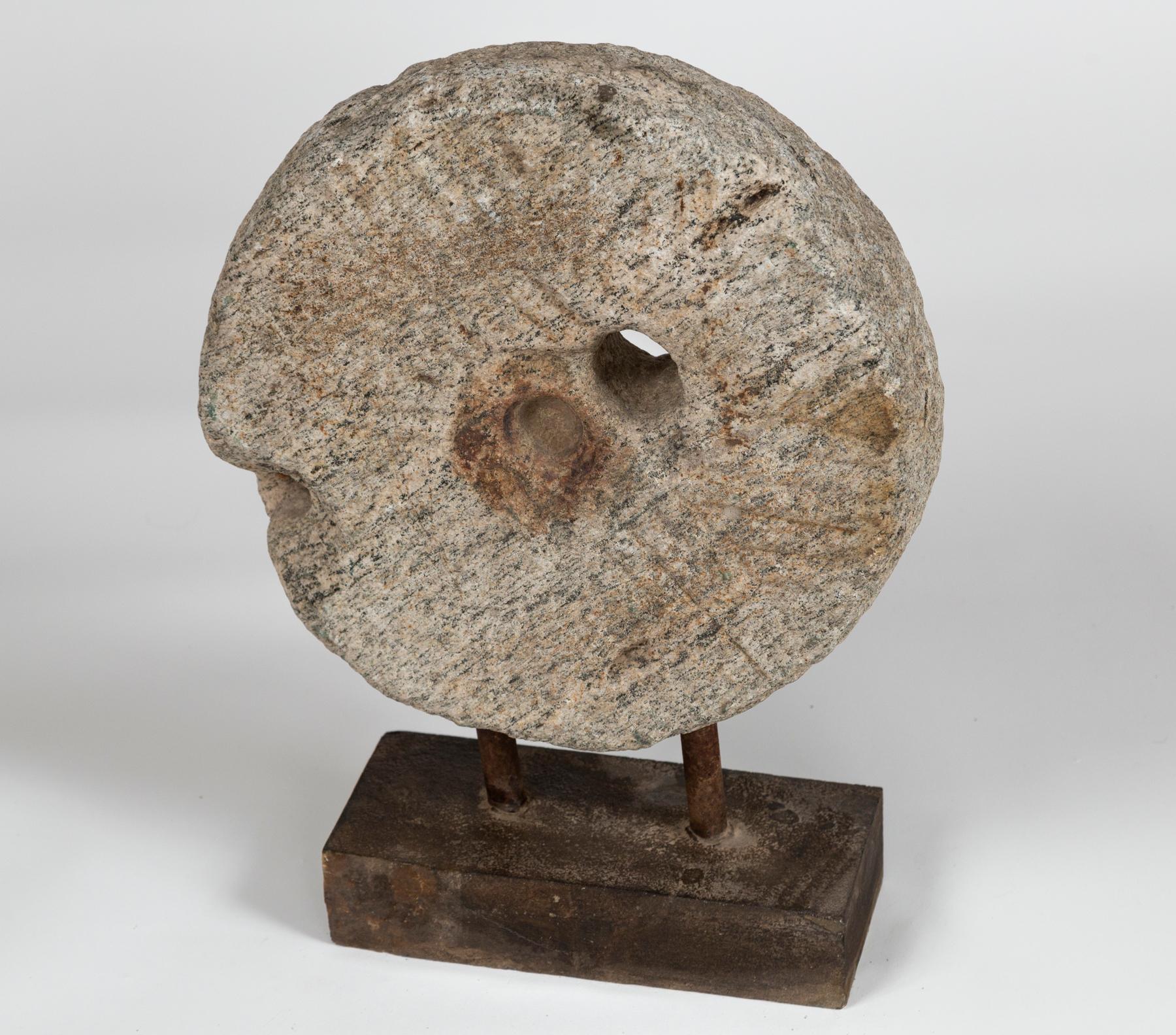 Pierre de moulin vintage sur base, 20e siècle. La meule de granit sculptée à la main et montée sur un socle crée une sculpture organique.