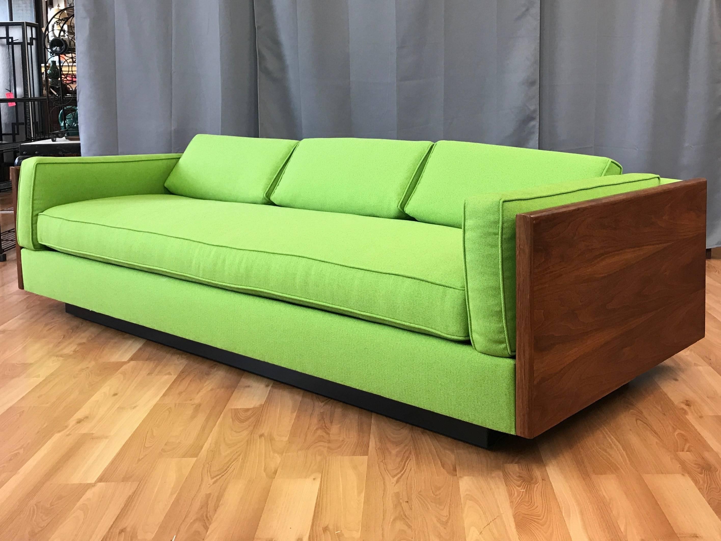 An extra-long and eye-catching 1970s case or box sofa with walnut sides and new upholstery, done in the style of Milo Baughman.

Substantial sides finished in bookmatched walnut with an exceptionally handsome and lively figure. Freshly dressed