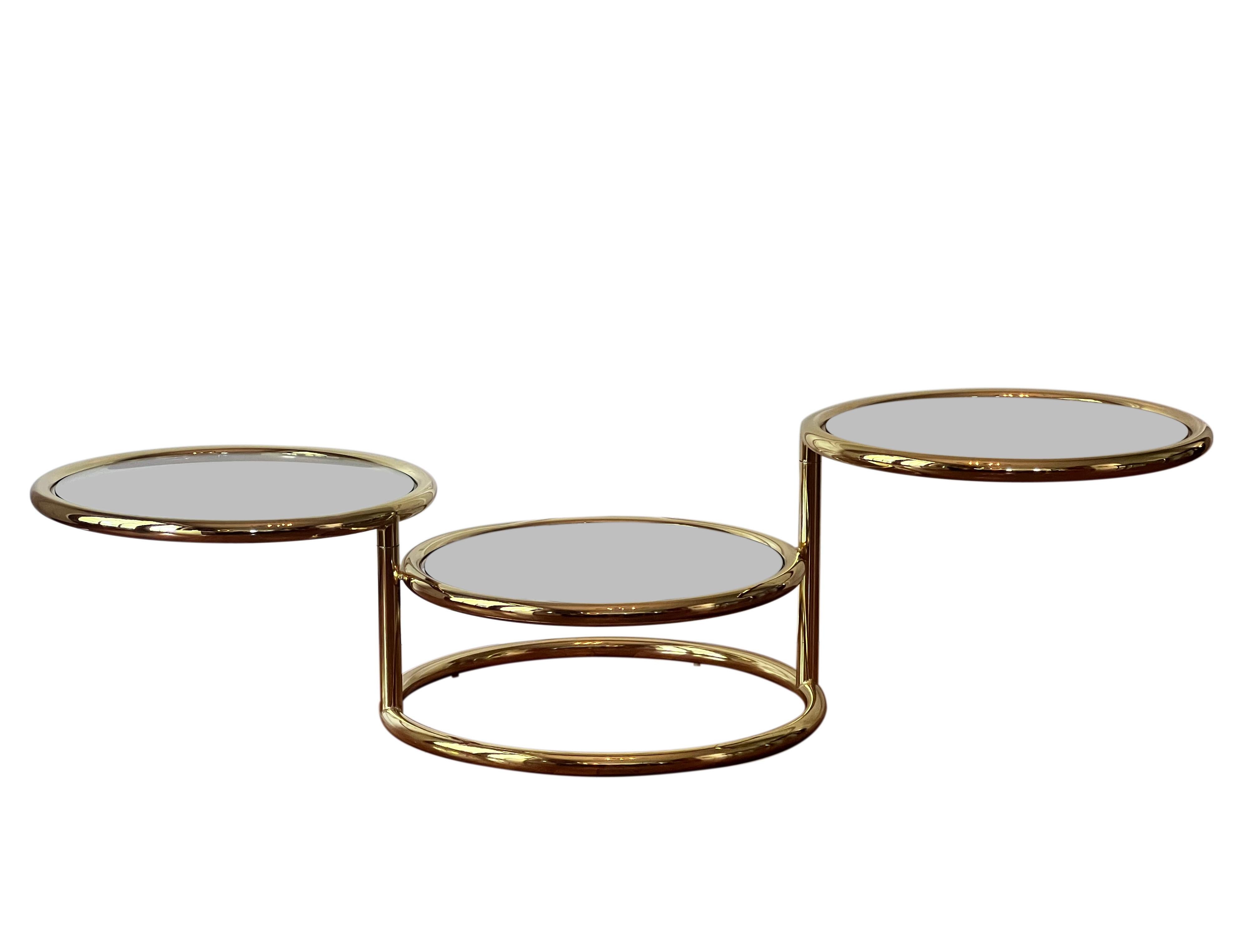 Gorgeous three-tier swivel coffee table with a high shine brass finish in the style of Milo Baughman, 1970's. 

An endlessly versatile table, the top two tiers smoothly swivel to create desired position allowing for a multitude of configurations