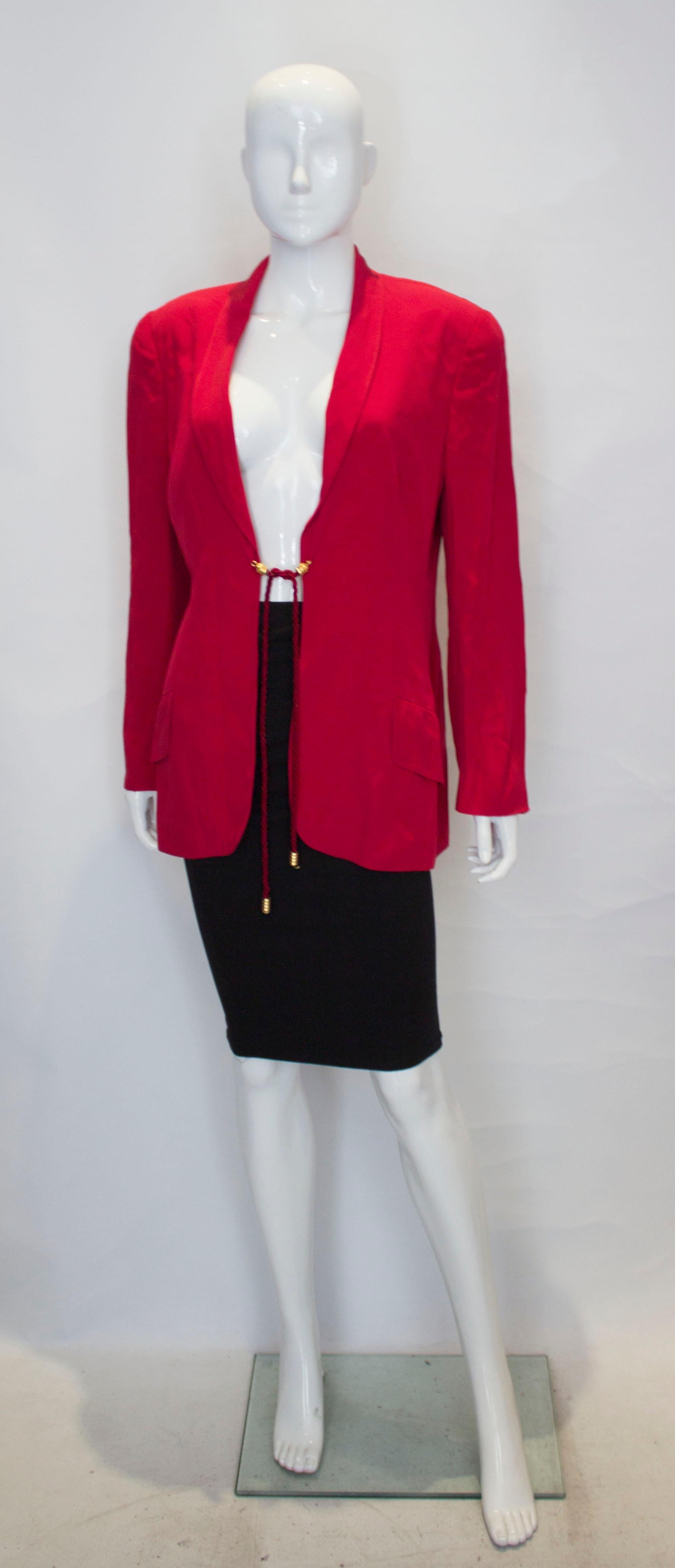  A headturning vintage red jacket by Mimmina . The jacket has a shawl collar , two flap pockets  and fastens with a rope tie.