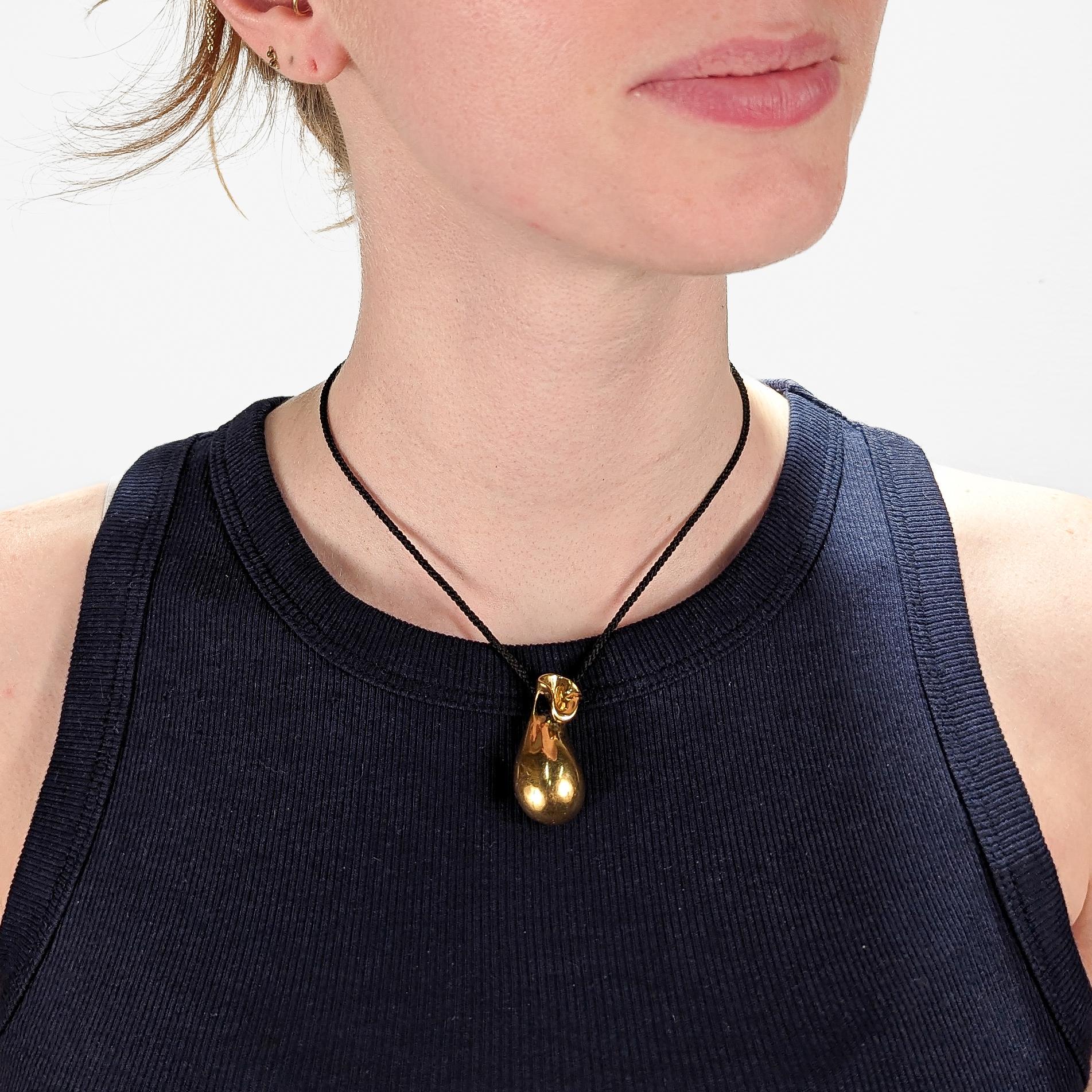 A fine signed, figural pendant necklace.

In 18k yellow gold.

By the renowned Greek jeweler - Minas Spiridis.

Entitled: The Golden Pouch

In the form of a (filled) cloth pouch with a hidden compartment to the reverse.

Designed in 1976.

In 1996,