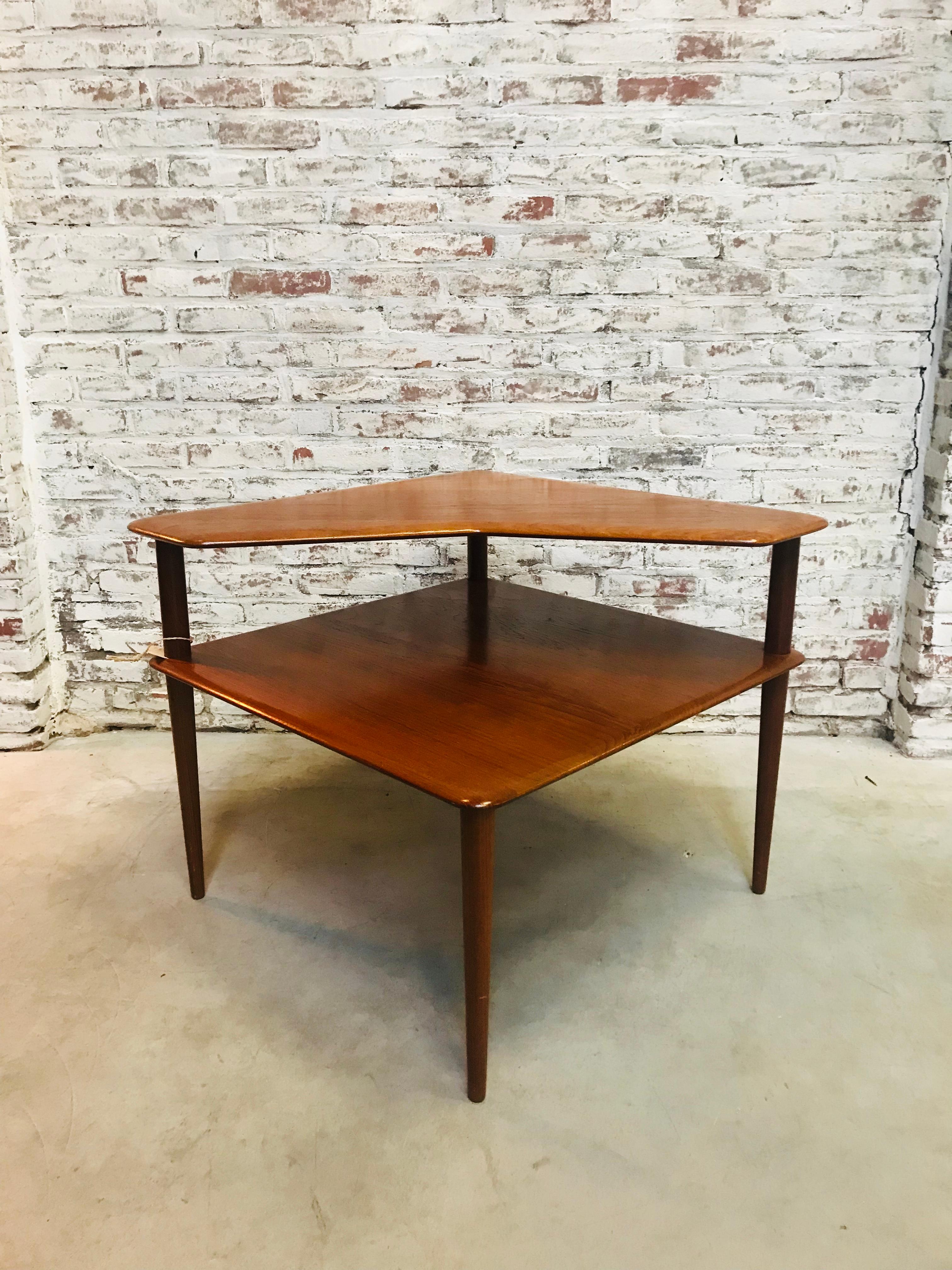 This teak coffee table, in a square shape, was designed by Peter Hvidt & Orla Mølgaard-Nielsen in the sixties. It was manufactured by France & Son and has a solid teak frame. The legs are slightly tapered and the storage compartment has the same