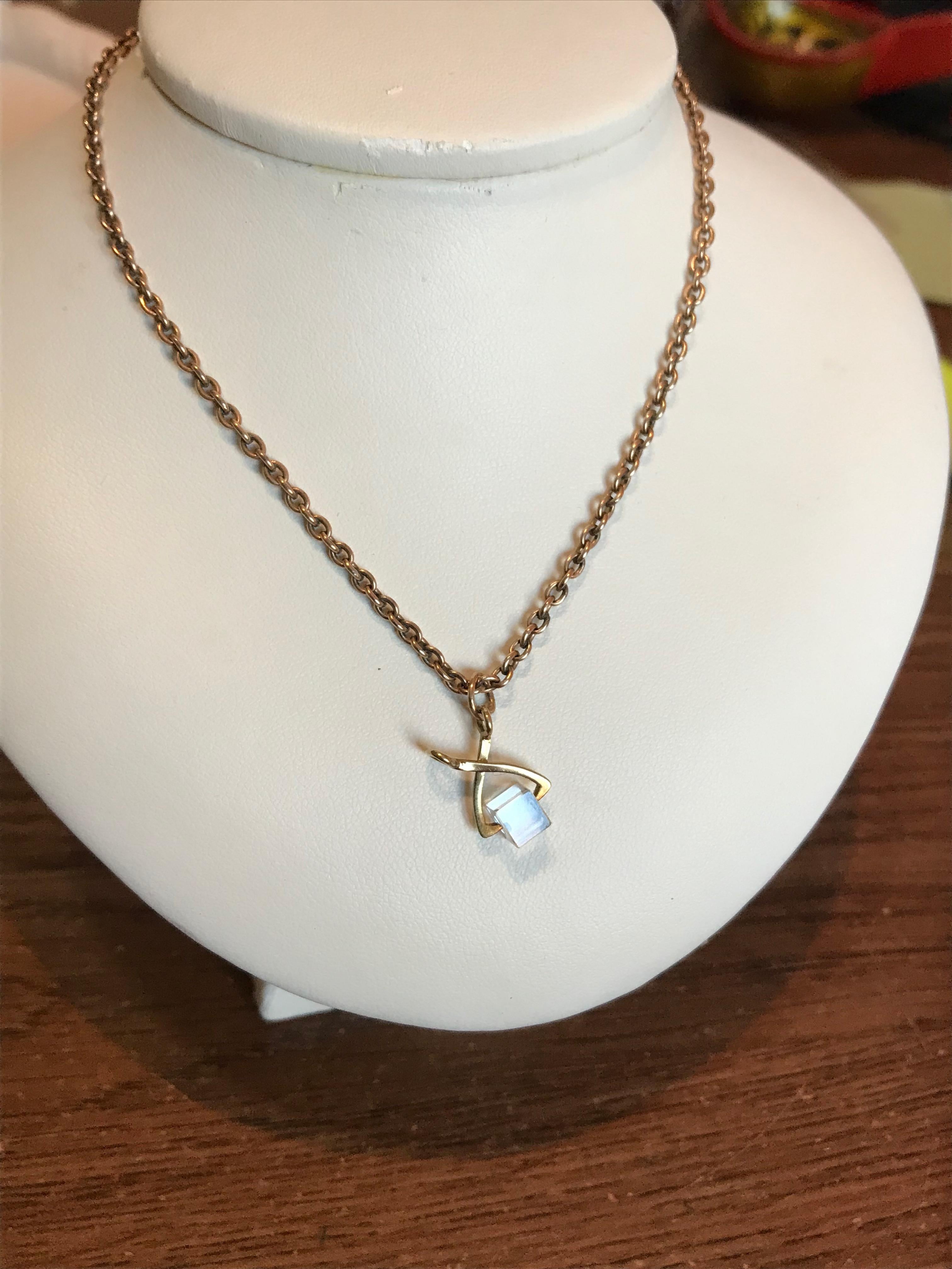 Designed as a pair of tiny 14k rose gold ice tongs in the form of scissors clutching a swiveling plexiglass ice cube, attached to a gold suspension ring.  May be worn on a bracelet or on a gold chain as pictured. 

1950s

3/4 in. (1.9 cm) long