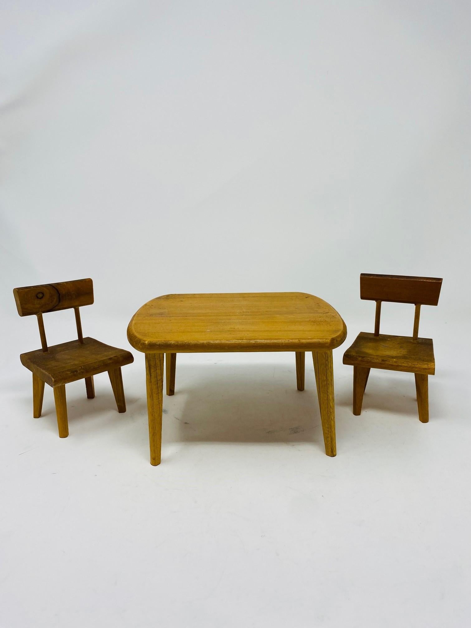 Gruppe von Miniatur-Holzmöbeln im Stil der Jahrhundertmitte, bestehend aus einem Tisch und zwei Stühlen.  Dieses Vintage-Set wurde in den frühen 1960er Jahren von Hand gefertigt.  Ideal für Dekoration oder Modelle.  Tabelle ist 4,1