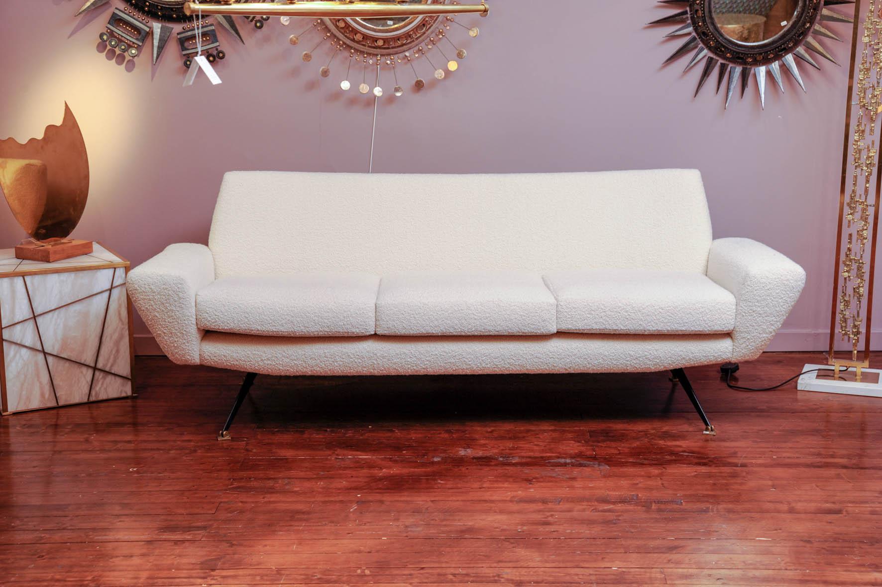 This three places vintage sofa has been reupholstered with Dedar bouclette. It stays on four metal legs with movable squared bases.