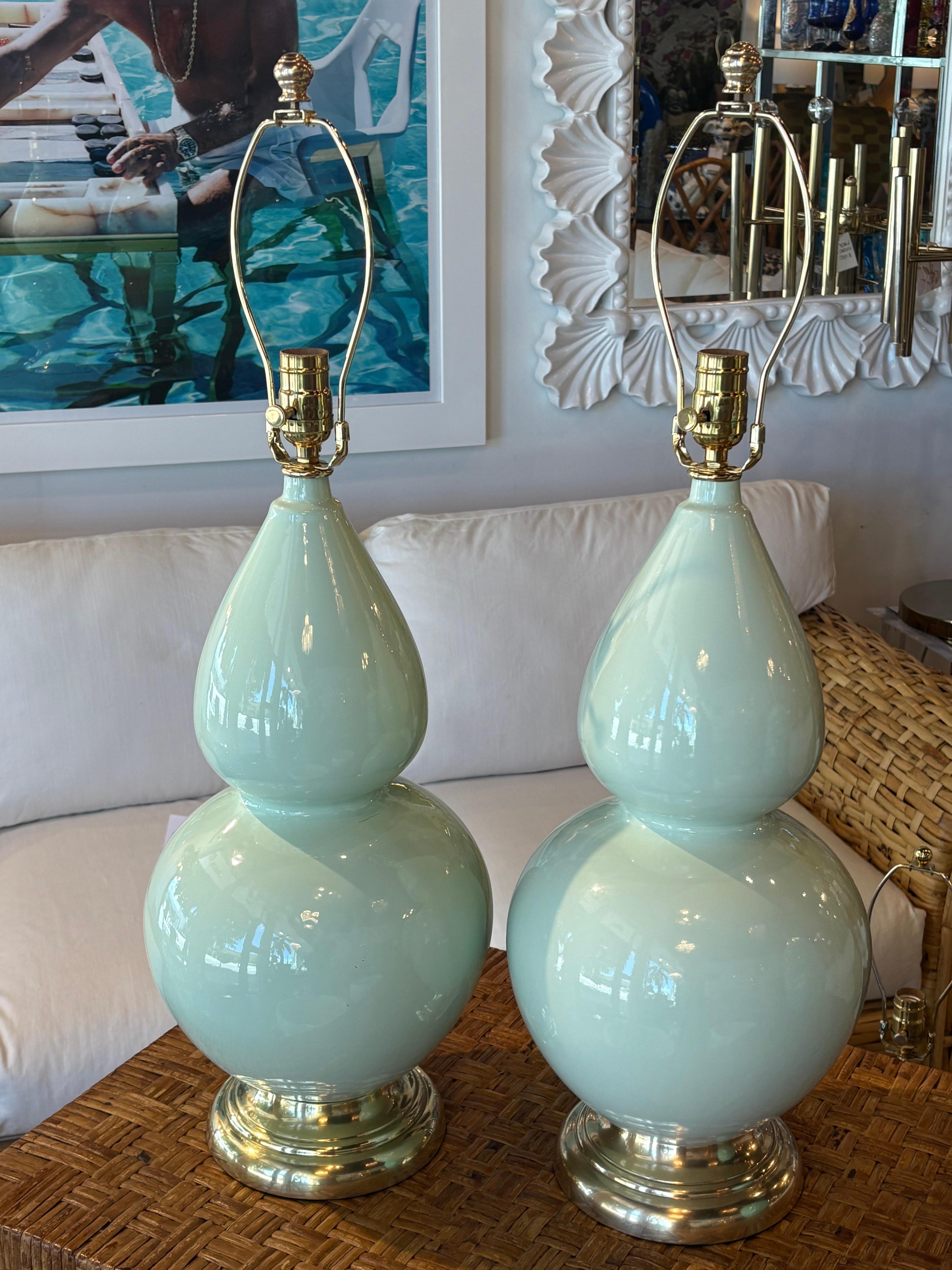 Vintage pair of soft mint green gourd shape, ceramic table lamps, 1970s. These have been newly wired with clear cords, 3 way sockets, new brass hardware. Original brass bases have been polished. Dimensions: 29.5 height to top of finial, 22.5 height