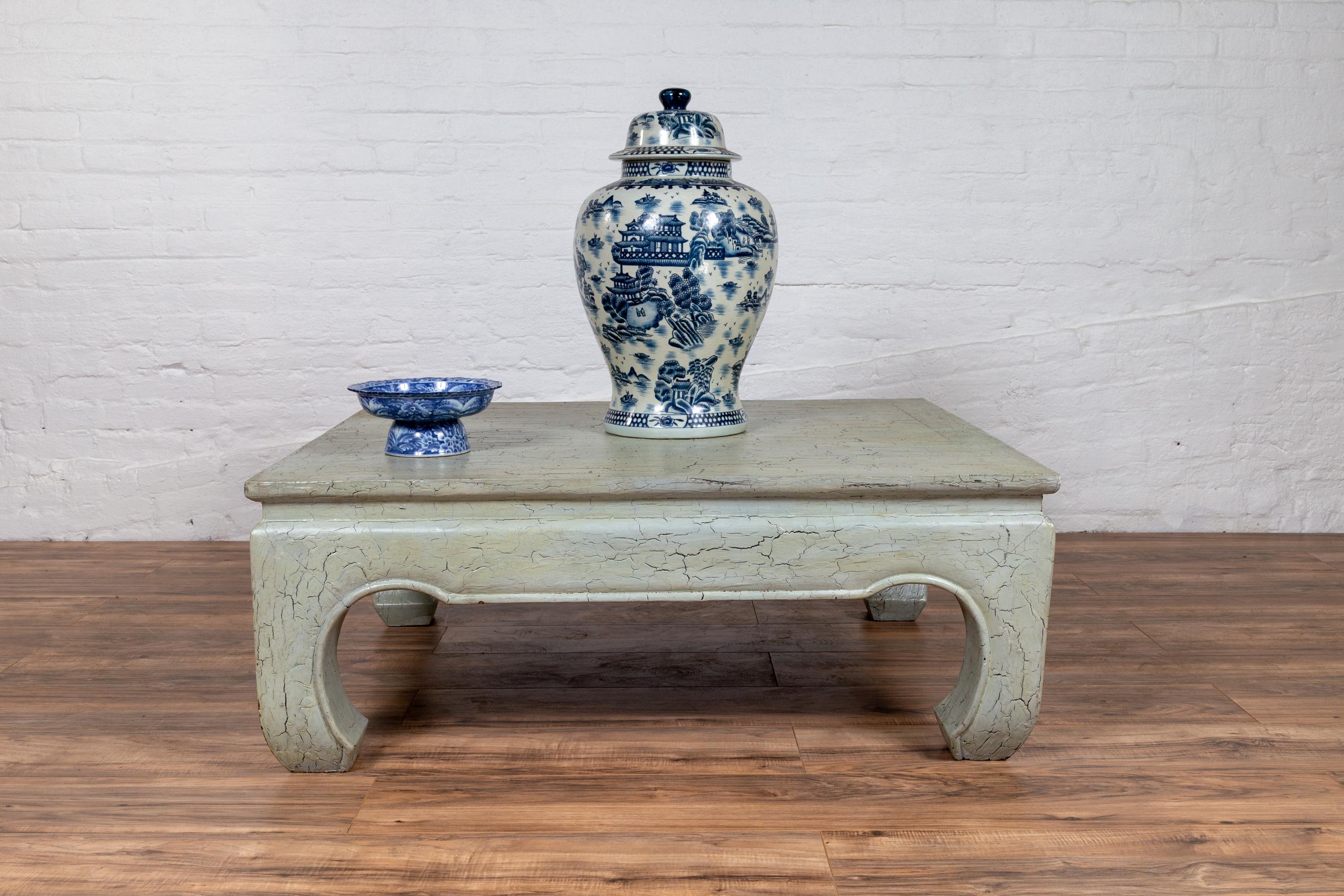 A Thai vintage wooden coffee table from the mid-20th century, with mint green crackled finish and chow legs. Born in Thailand during the midcentury period, this charming coffee table attracts our eyes with its distressed mint green finish.