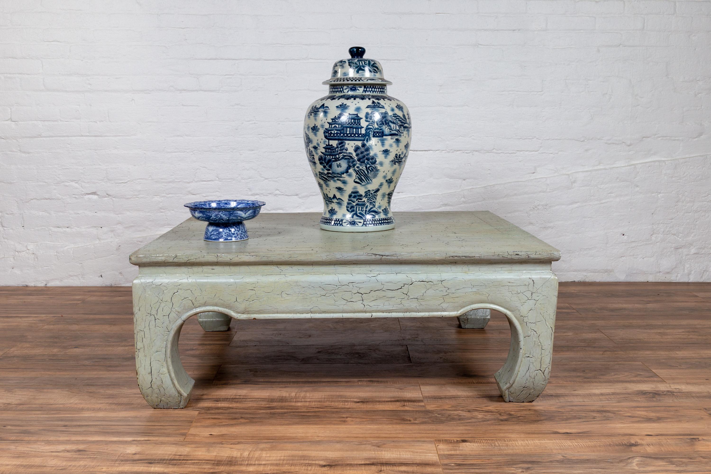 Table basse vintage en bois du milieu du 20e siècle, avec une finition craquelée vert menthe et des pieds en chow. Cette table basse vintage en bois du milieu du XXe siècle, qui nous captive avec sa finition craquelée vert menthe en détresse, est