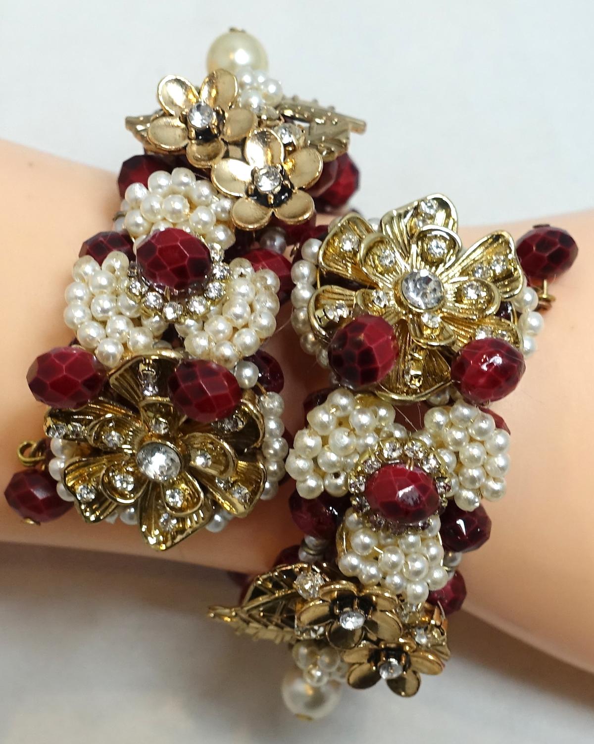 We believe this is a Miriam Haskell vintage wrap bracelet with burgundy glass beads in the center with clear crystals in a floral design. This wrap bracelet is in a gold tone setting and measure 9” around the inside. The centerpiece is 1” wide and